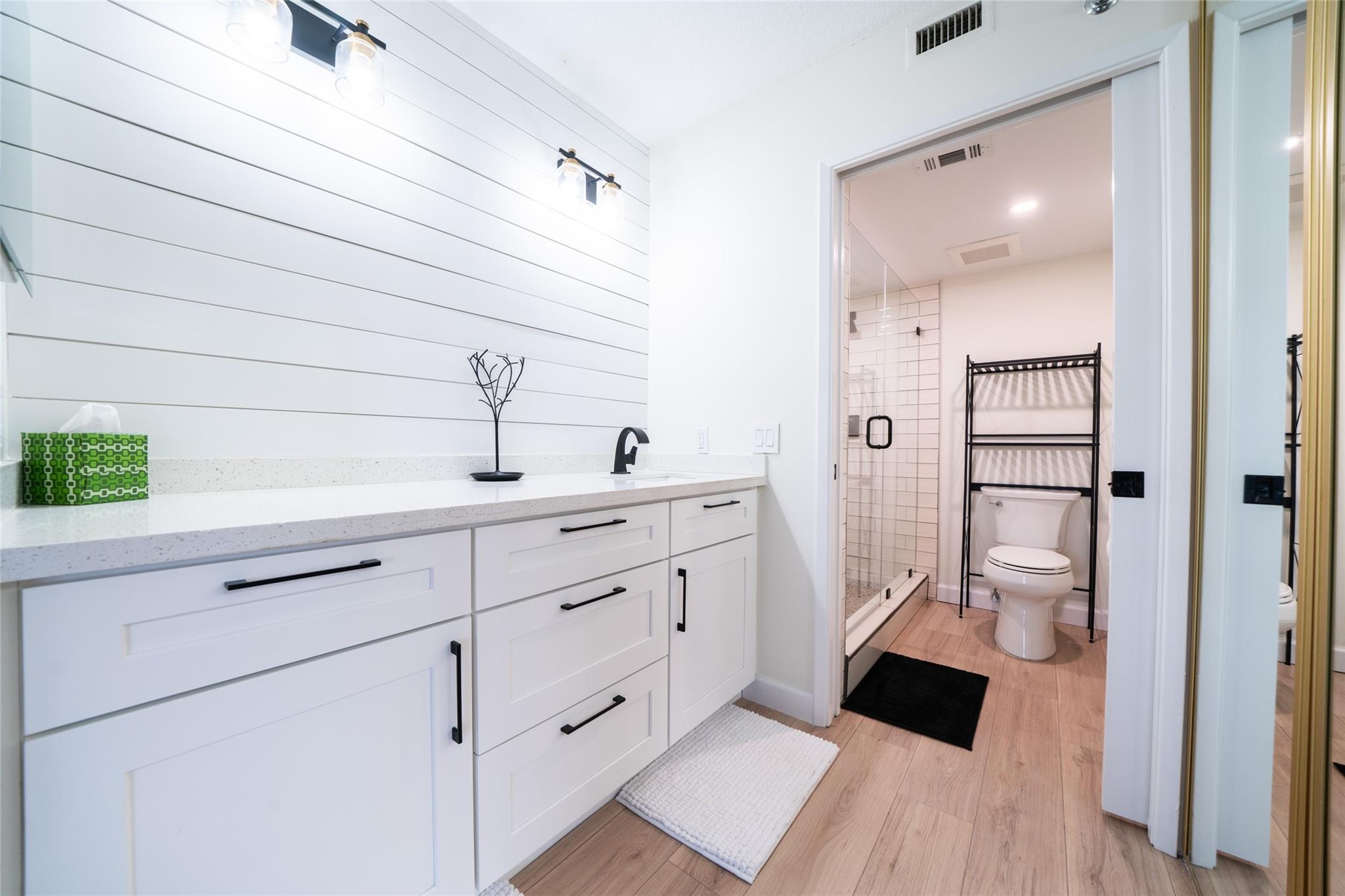 Primary dressing area leading into walk-in closet and bathroom