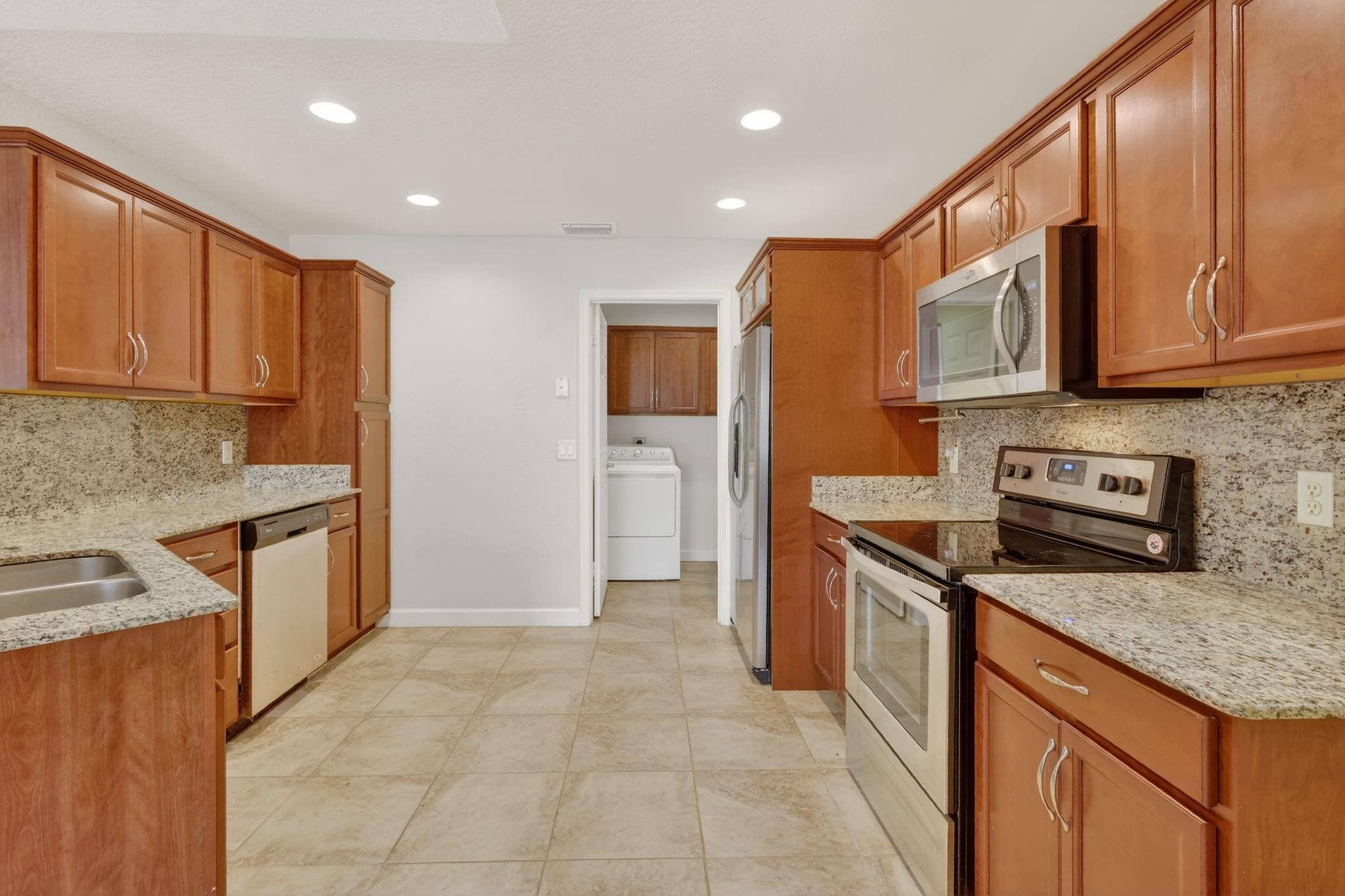 large kitchen with granite counters and anite backsplash