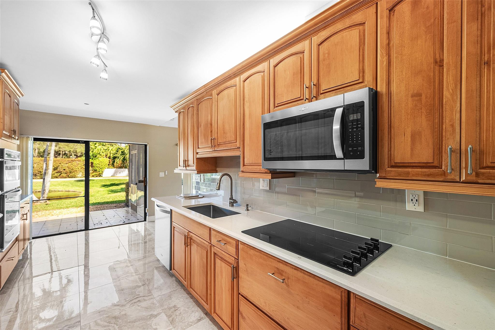 Plenty of cabinet space in this kitchen- beautiful tiled backsplash and under and over cabinet lighting.
