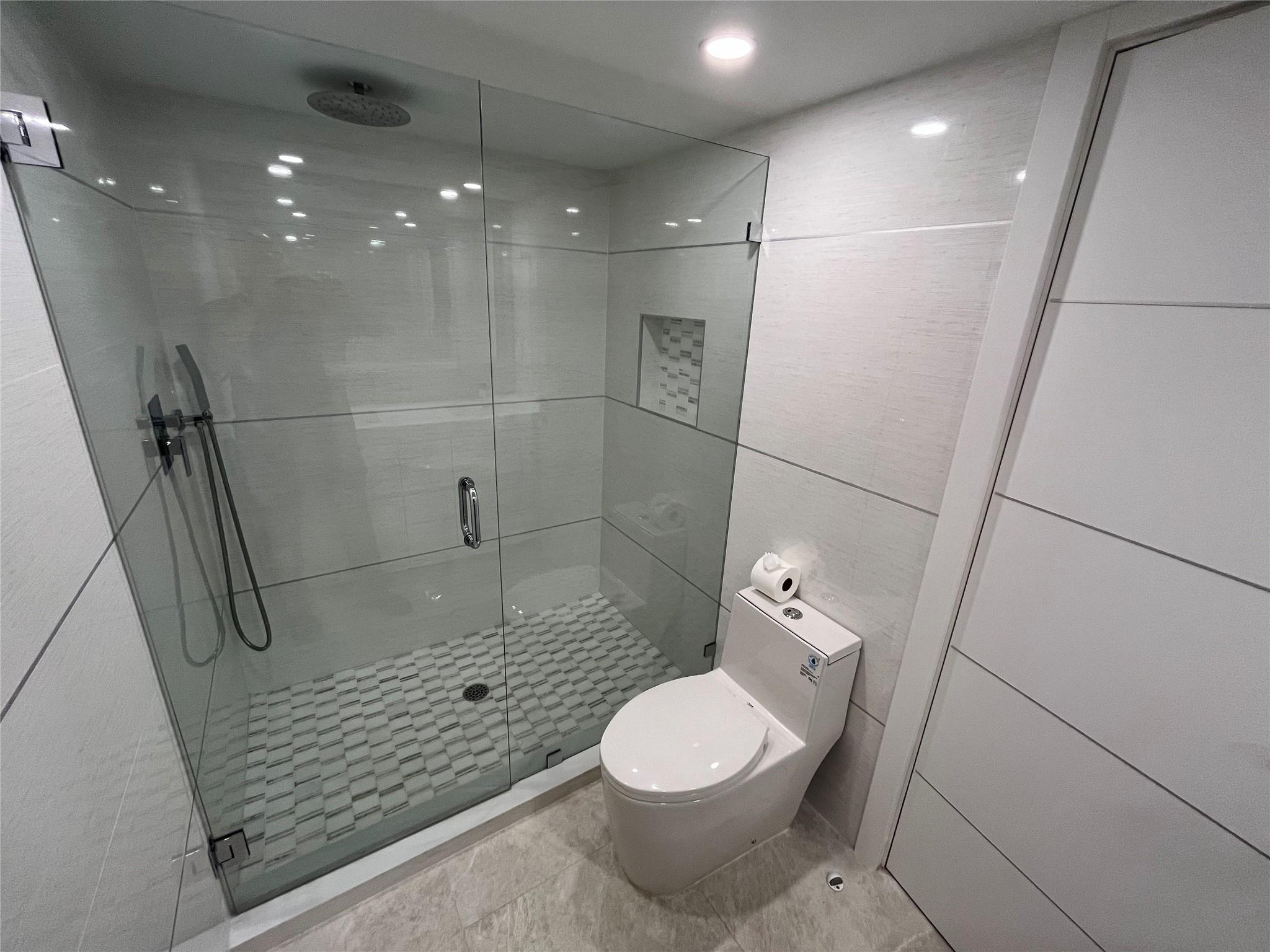 The hall bathroom includes a step-in full-glass shower.
