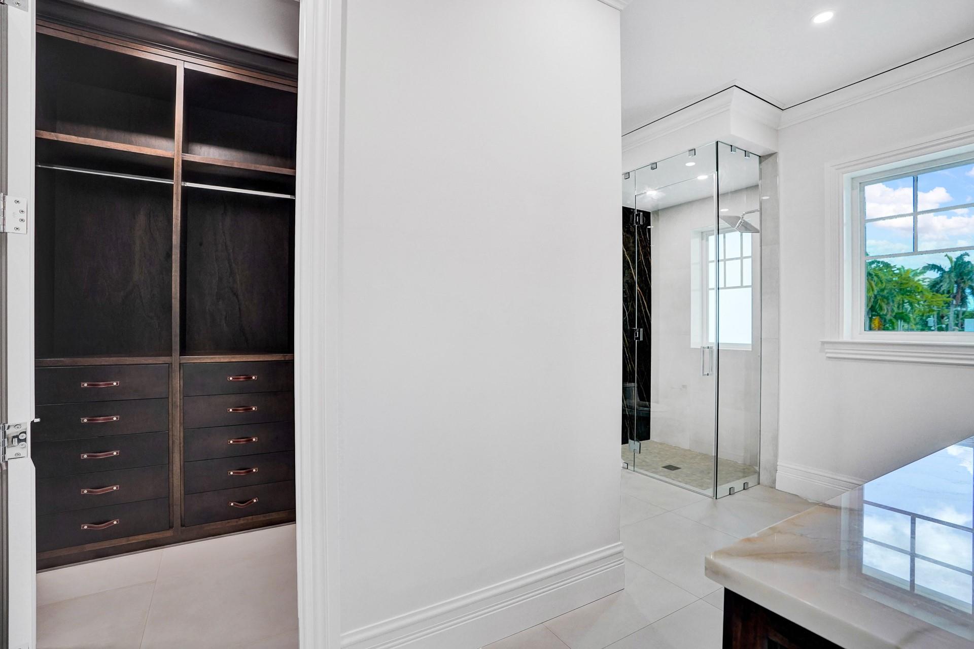 The primary suite boasts separate his-and-hers bathrooms; his bathroom includes a stylish vanity and a large walk-in closet.