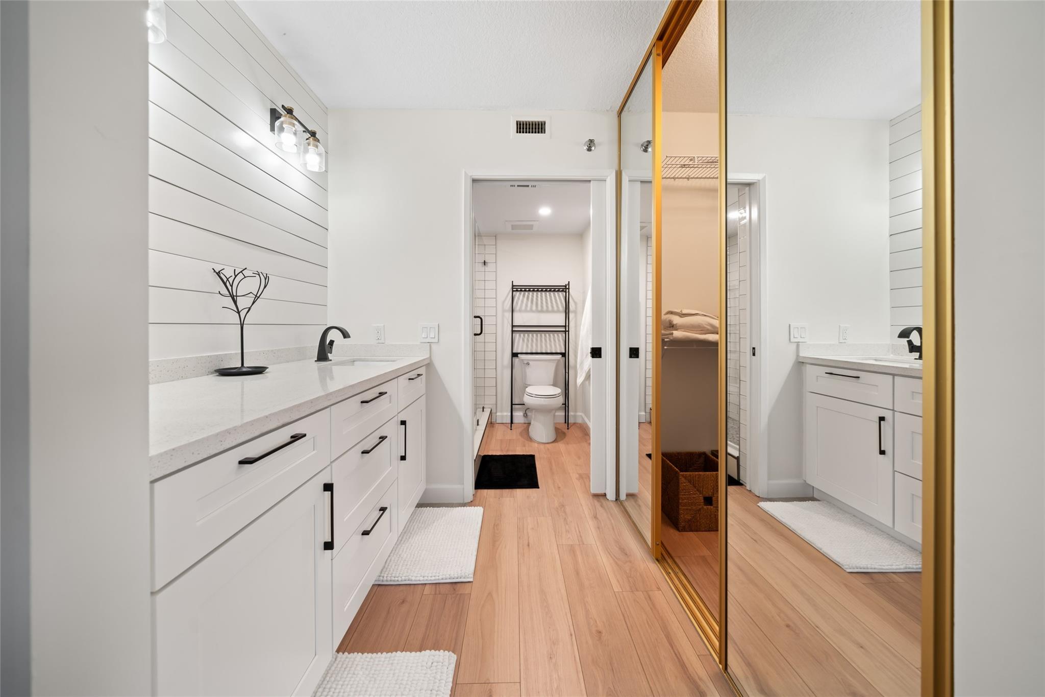 Primary dressing area leading into walk-in closet and bathroom