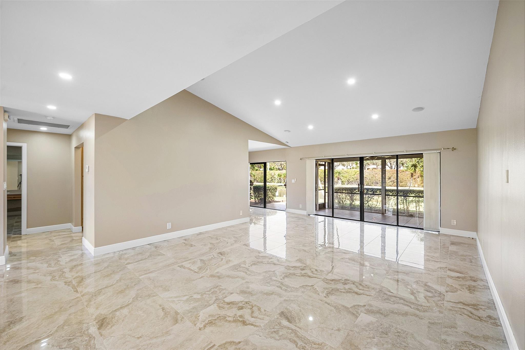 View of great room to eat in kitchen space - showing both screened and covered back patio and open air patio space.