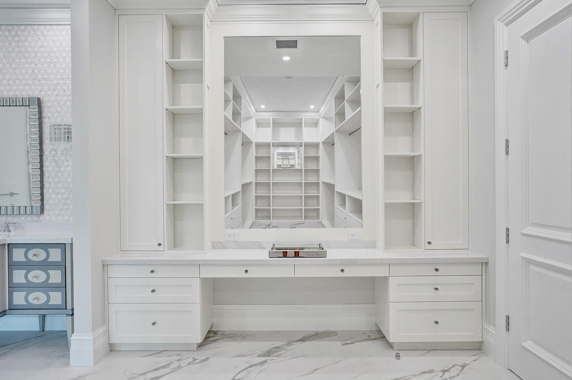 The primary suite boasts separate his-and-hers bathrooms; her bathroom features a spa-like soaking tub, makeup vanity, and a spacious walk-in closet.