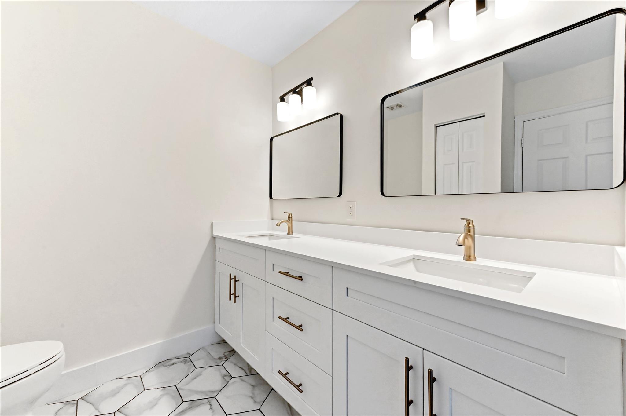 Double sink vanity and linen closet in primary bathroom