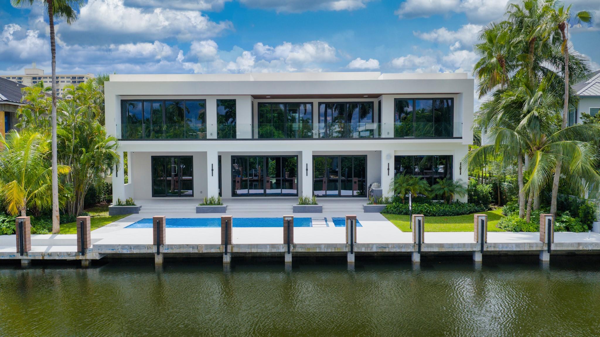 A focused aerial of a modern residence with a resort-style pool and dock directly on the canal.