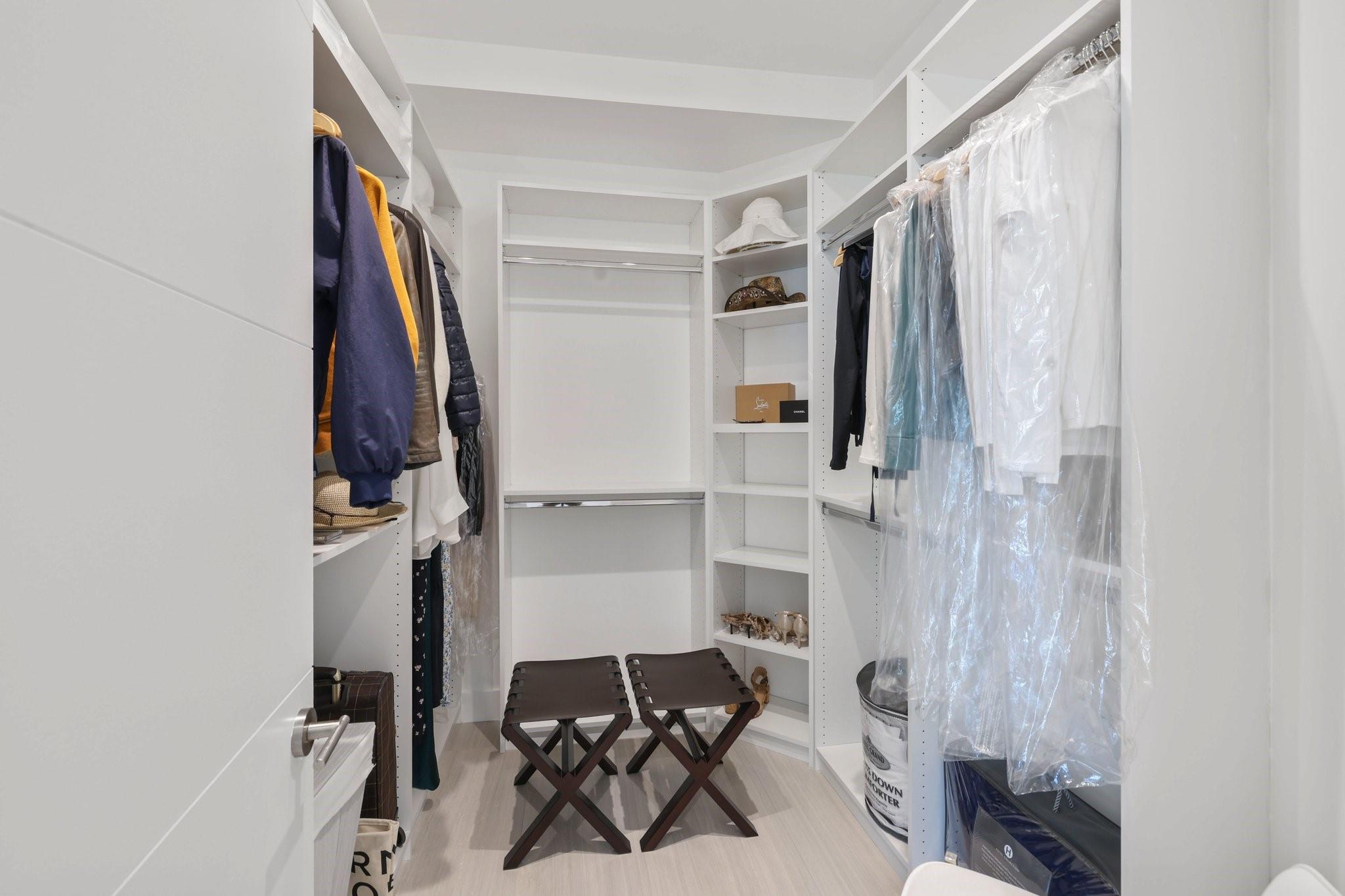 Large primary closet with built in cabinetry