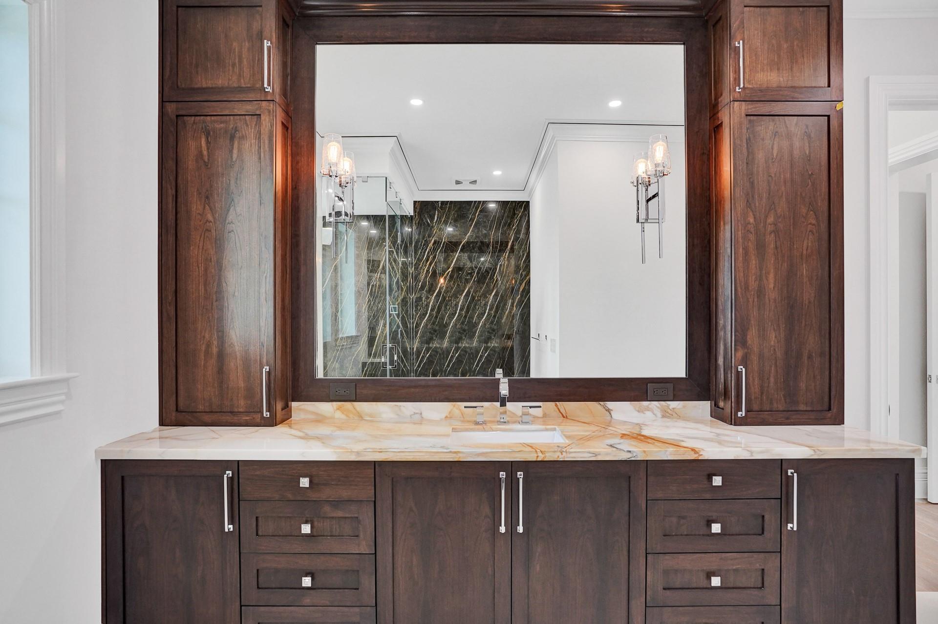 The primary suite boasts separate his-and-hers bathrooms; his bathroom includes a stylish vanity and a large walk-in closet.