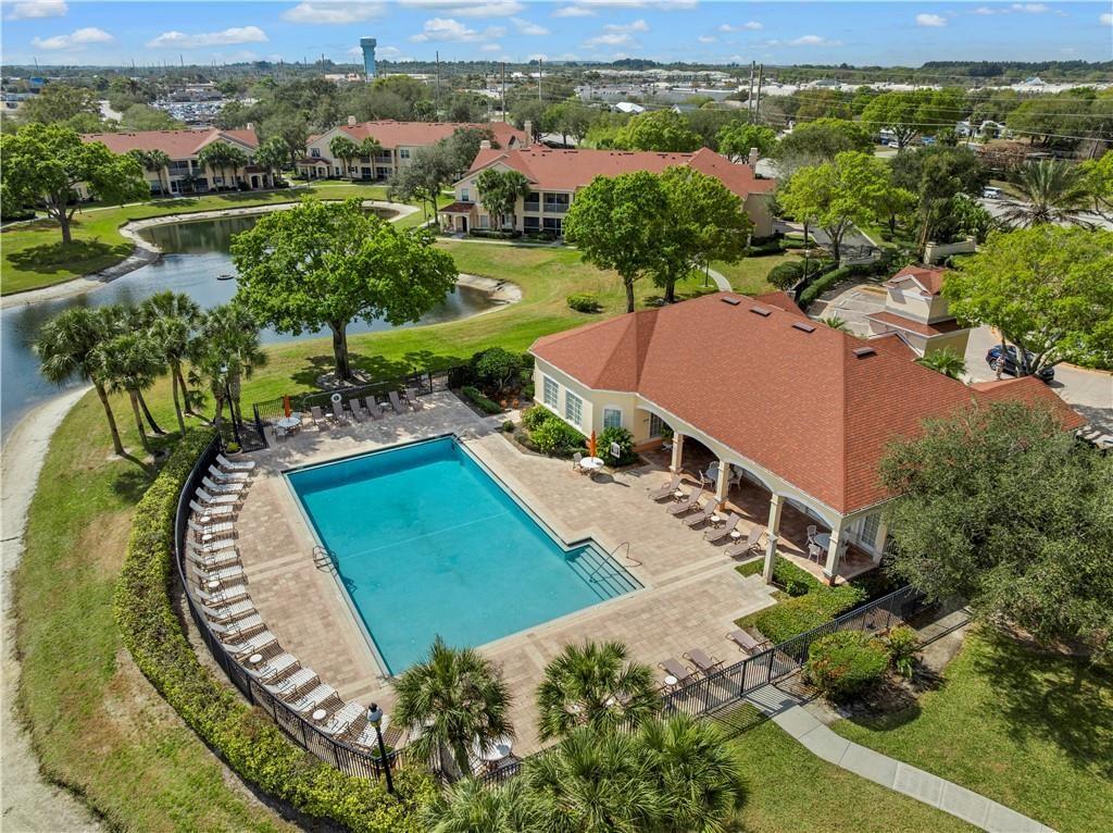 Community pool featuring a patio area, expansive deck area for sunning, and a water view