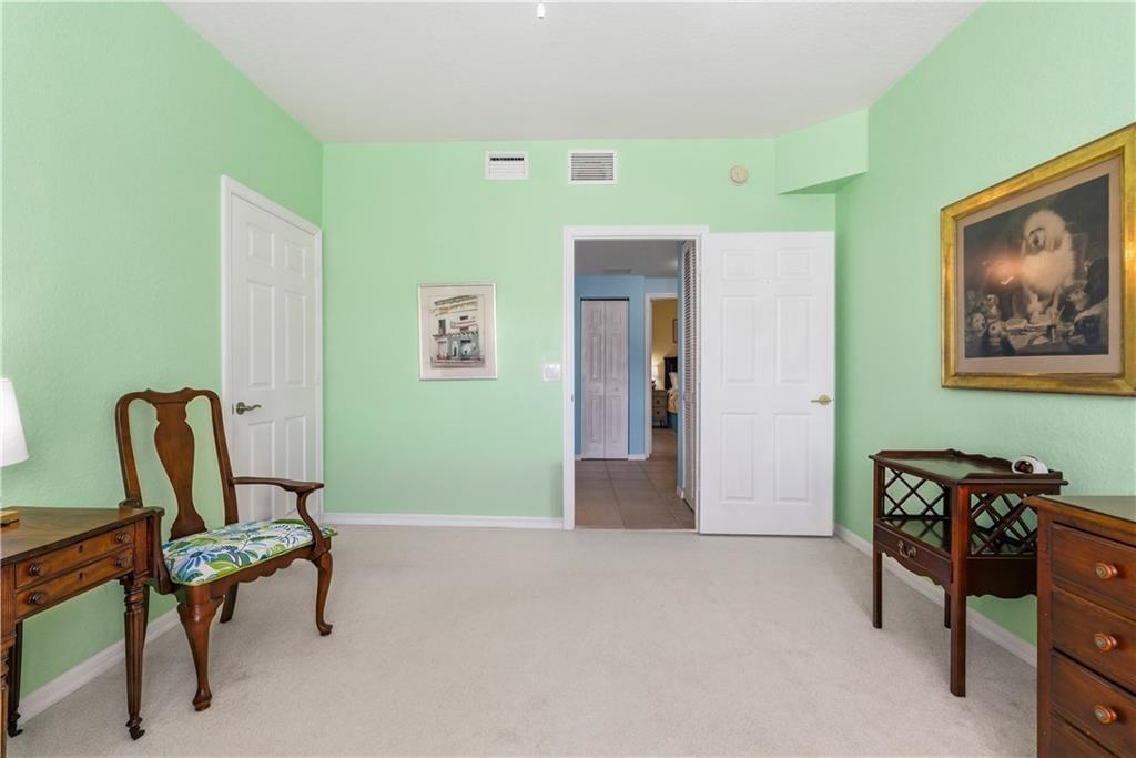 Bedroom 2 with ceiling fan and light colored carpet