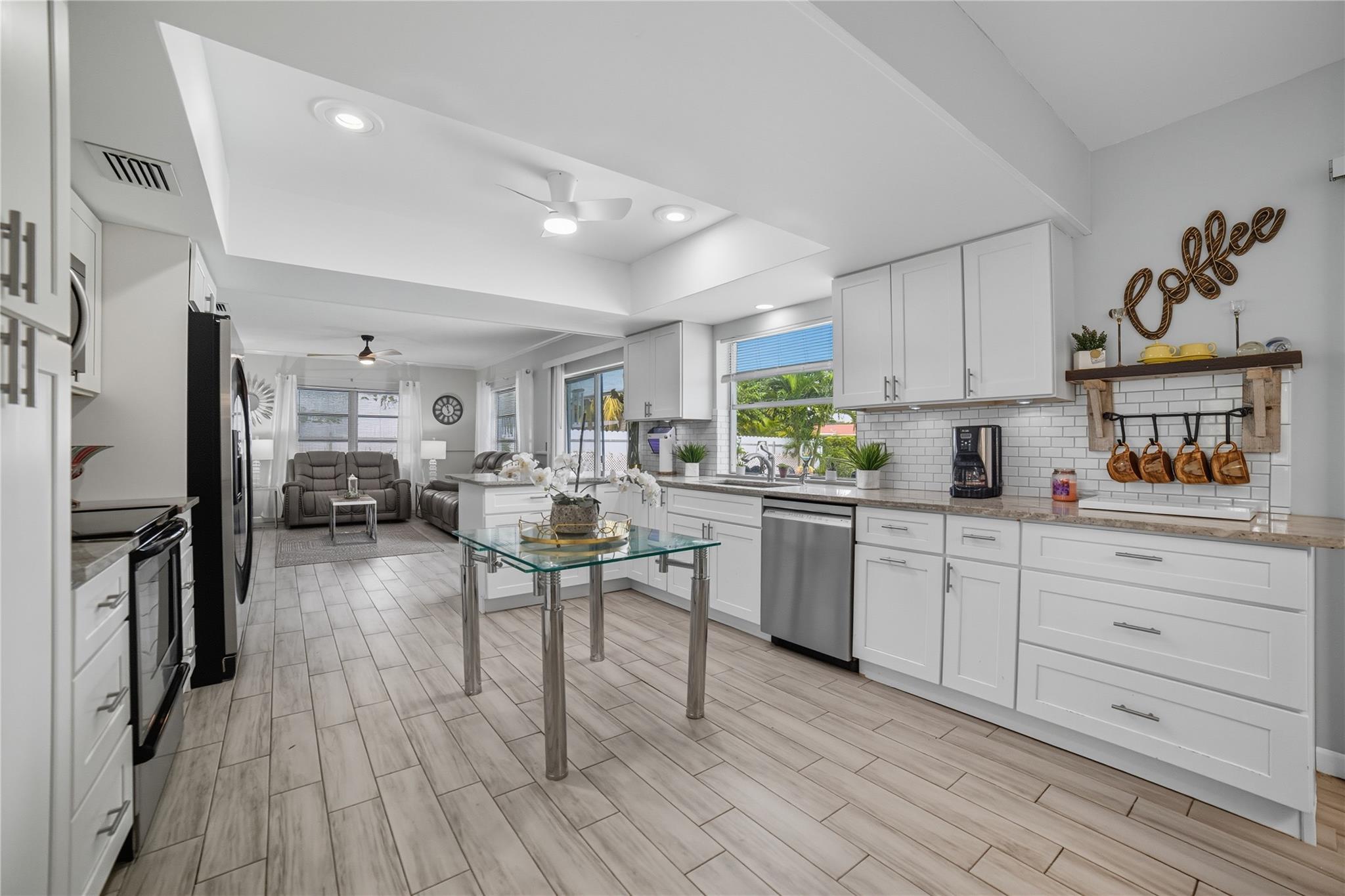Open concept remodeled kitchen, shaker style wood cabinets, granite countertops, tile backsplash, stainless steel appliances