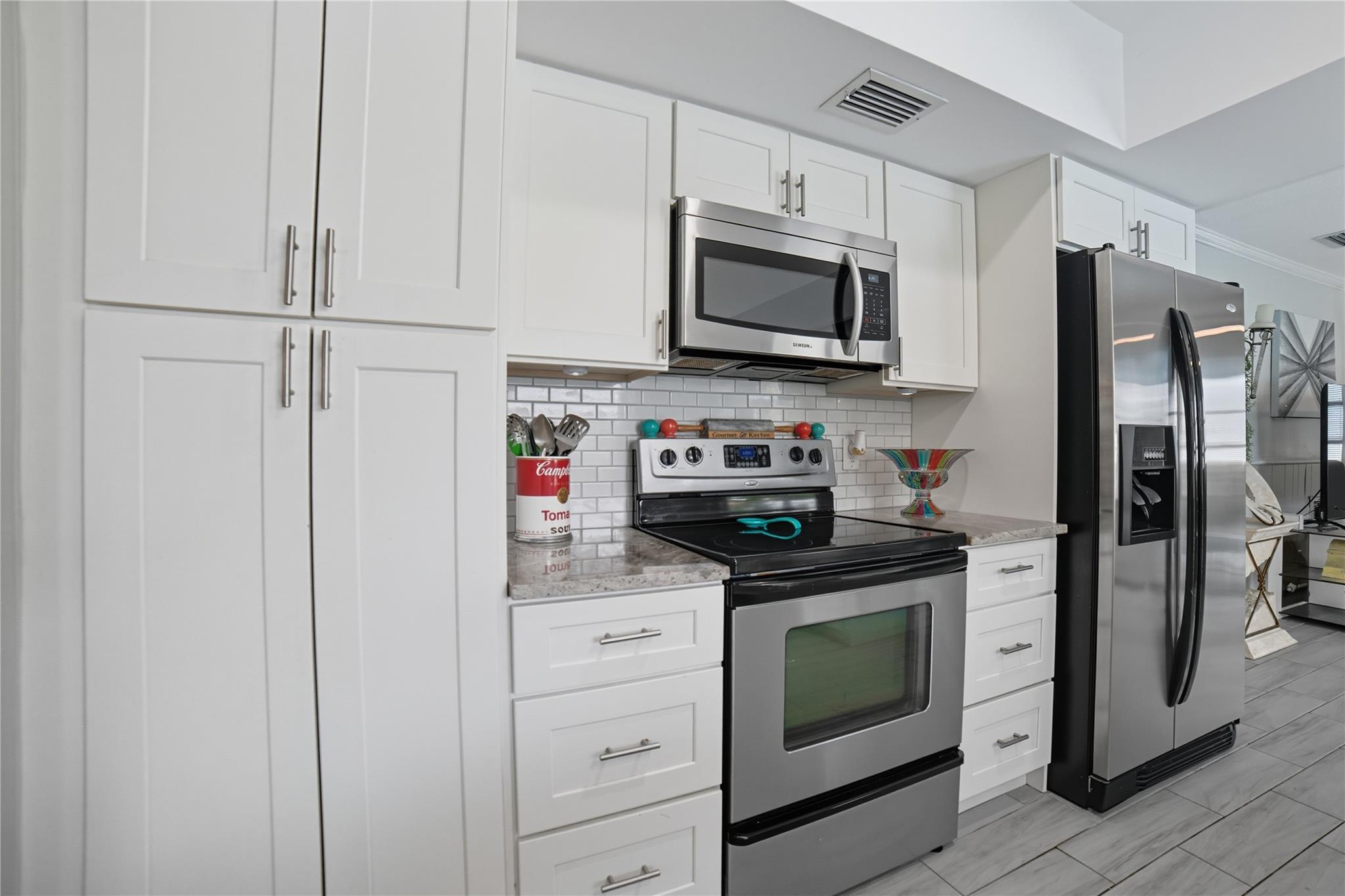 Open concept remodeled kitchen, shaker style wood cabinets, granite countertops, tile backsplash, stainless steel appliances