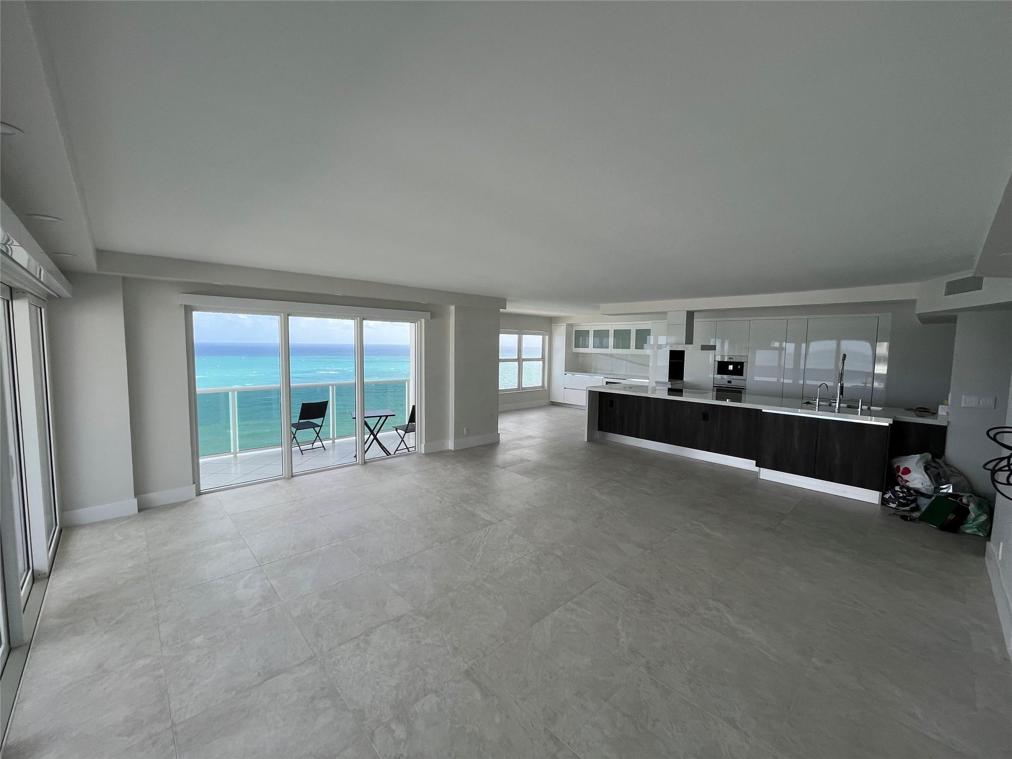 The kitchen is stream-lined and open. The kitchen island contrasts beautifully with the white floor-to-ceiling white cabinets.