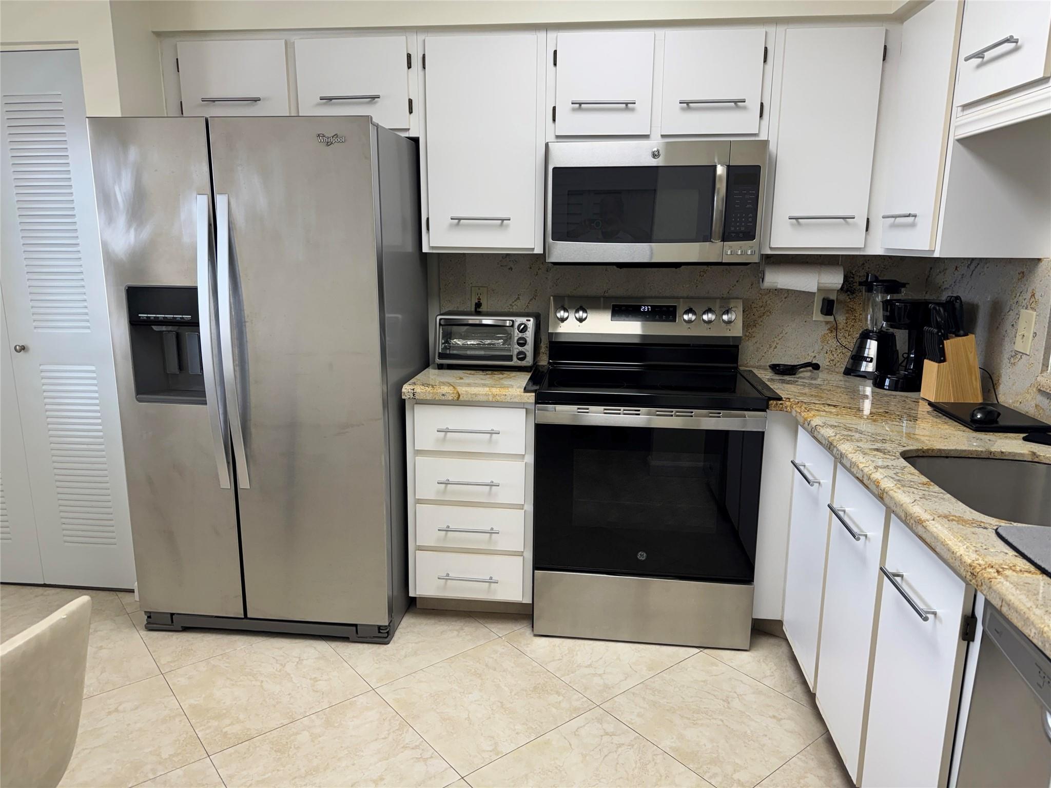 Updated kitchen with granite countertops and backsplash, stainless steel appliances including a new oven and spacious pantry.