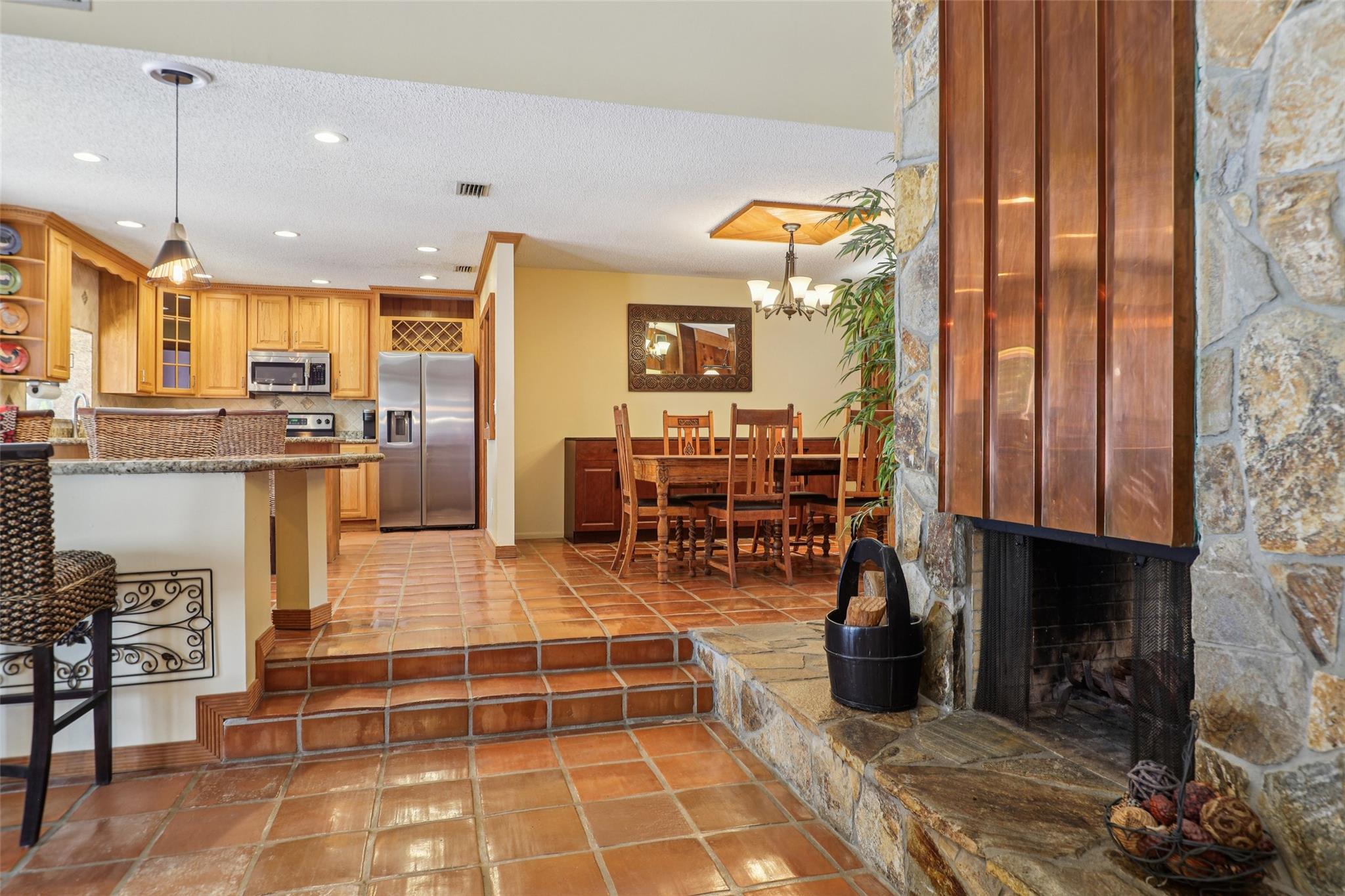 Large double-sided fireplace lined with copper detail for easy winter comfort. Divided sun room from living room and dining area.