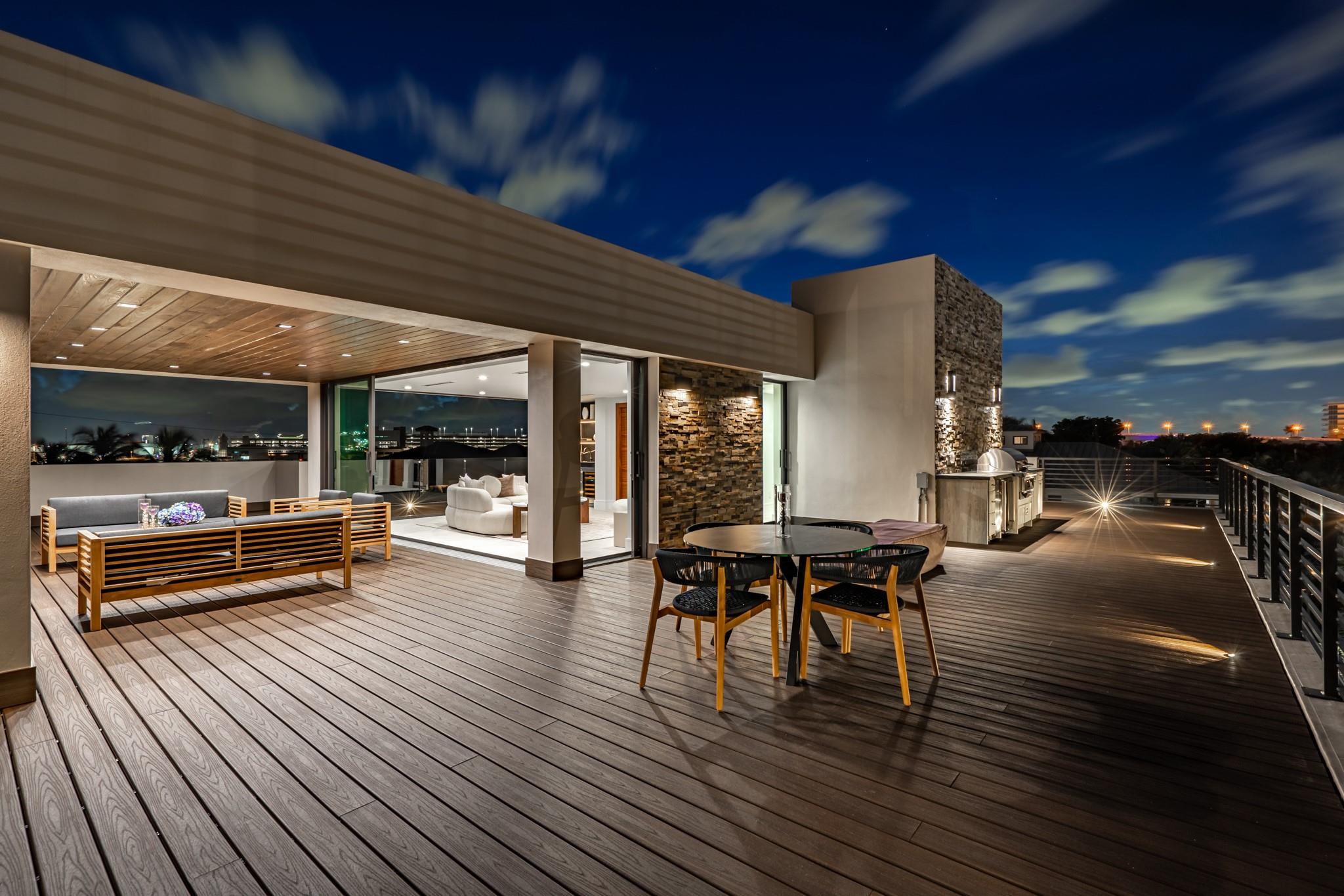 Outside sitting area on the third level with outdoor kitchen, jacuzzi, and firepit.