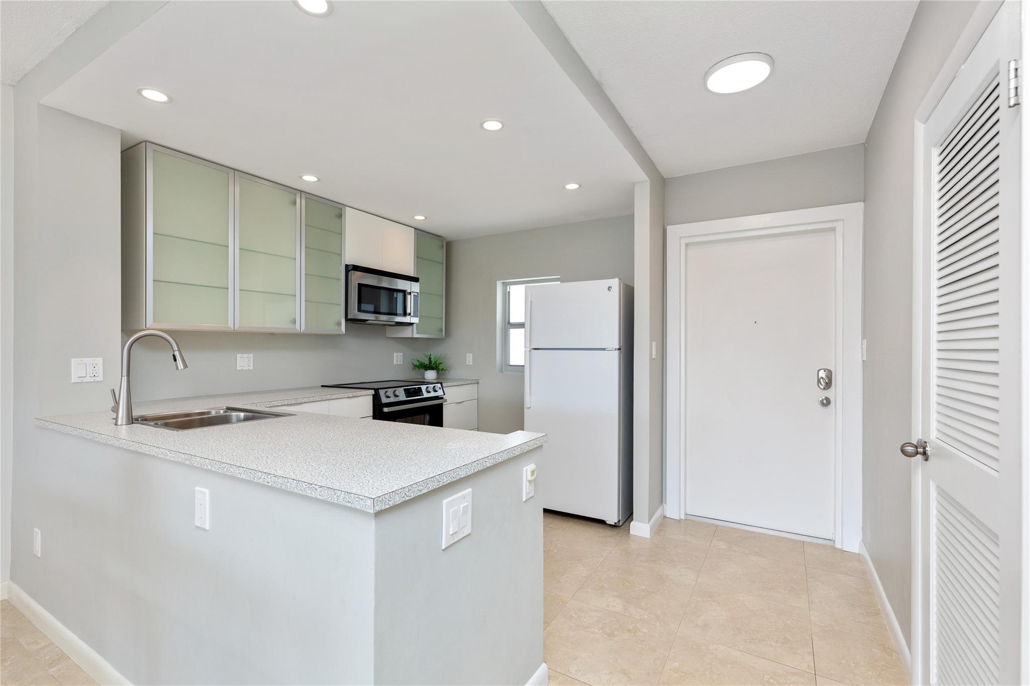 Kitchen with modern updates. Entry door into residence at right.