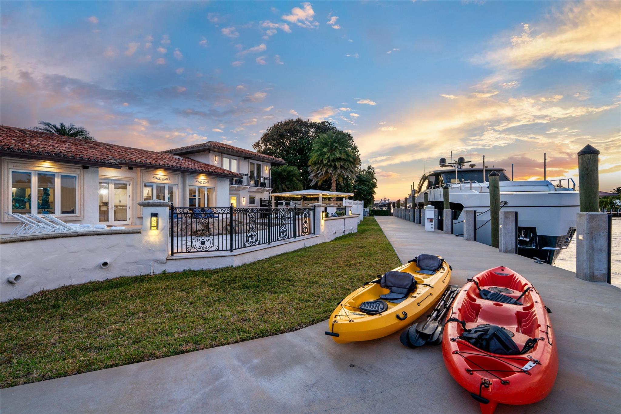 A stunning twilight waterfront perspective showcasing the estate’s expansive lawn, illuminated interiors, and impressive deep-water dockage along the Intracoastal. Serene yet commanding, this exceptional setting captures the essence of Fort Lauderdale’s premier yachting lifestyle.