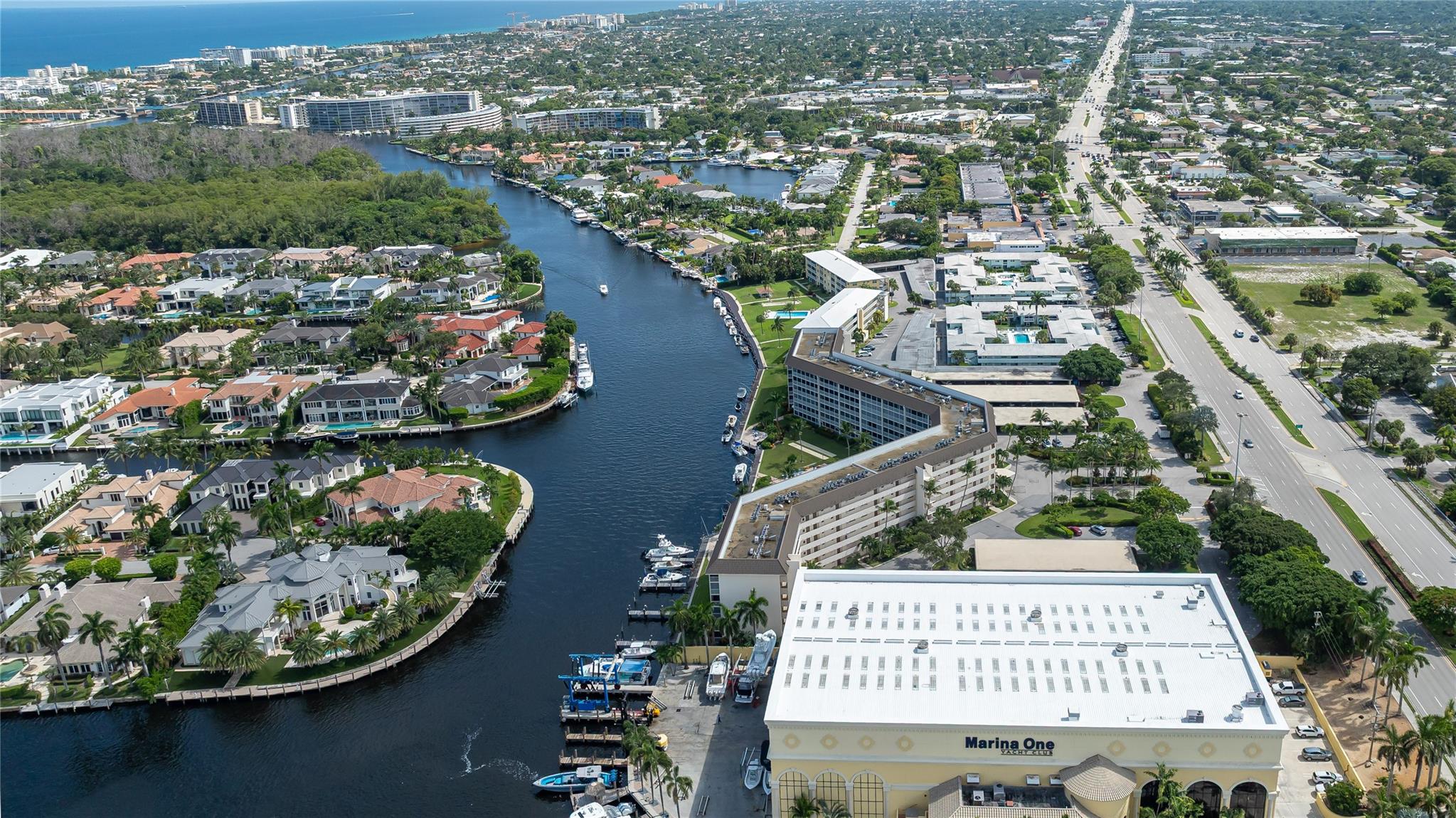 Beautiful Hillsboro River canal along River House Towers with Marina One Yacht Club at North of community in foreground.