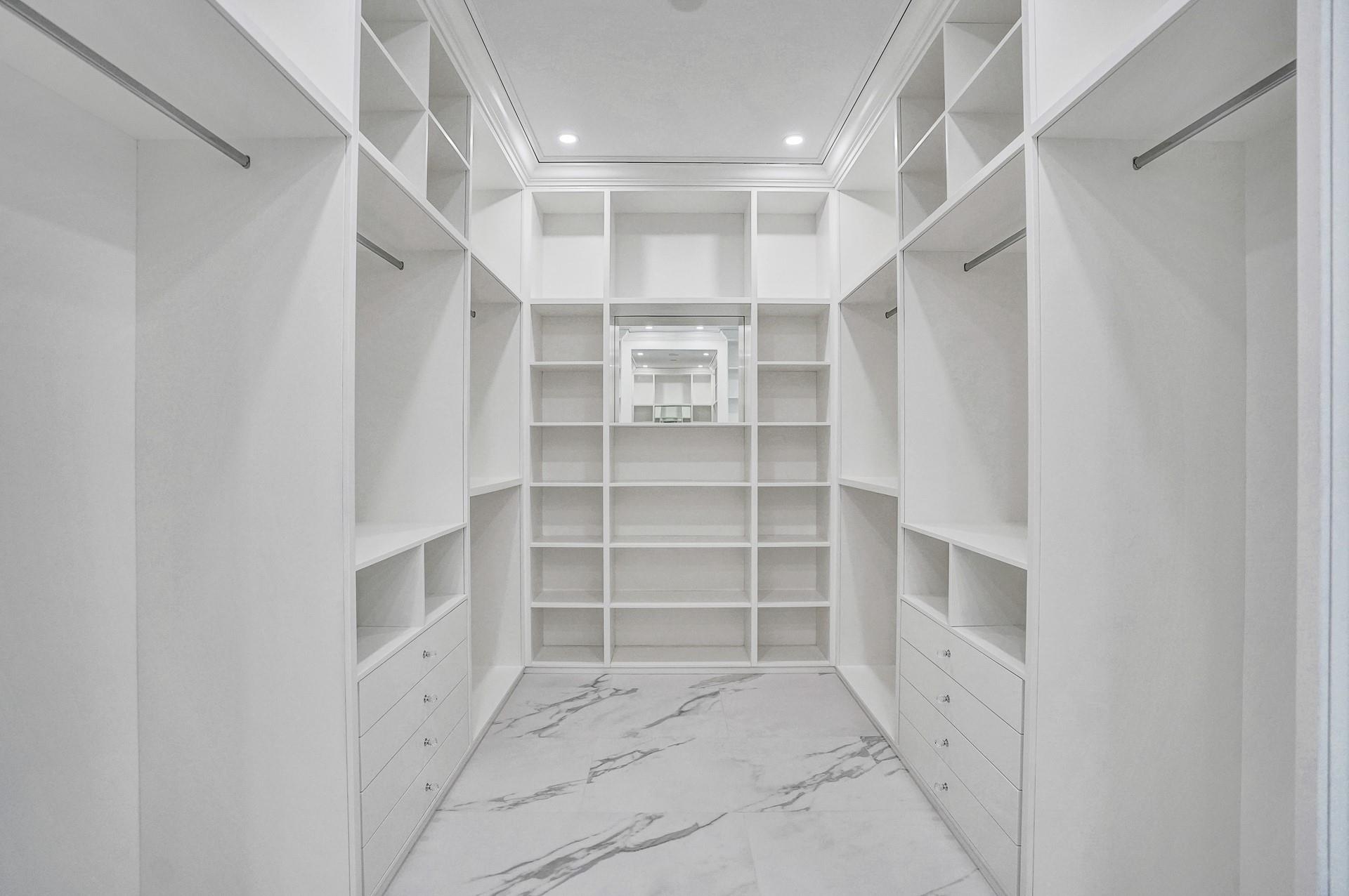 The primary suite boasts separate his-and-hers bathrooms; her bathroom features a spa-like soaking tub, makeup vanity, and a spacious walk-in closet.