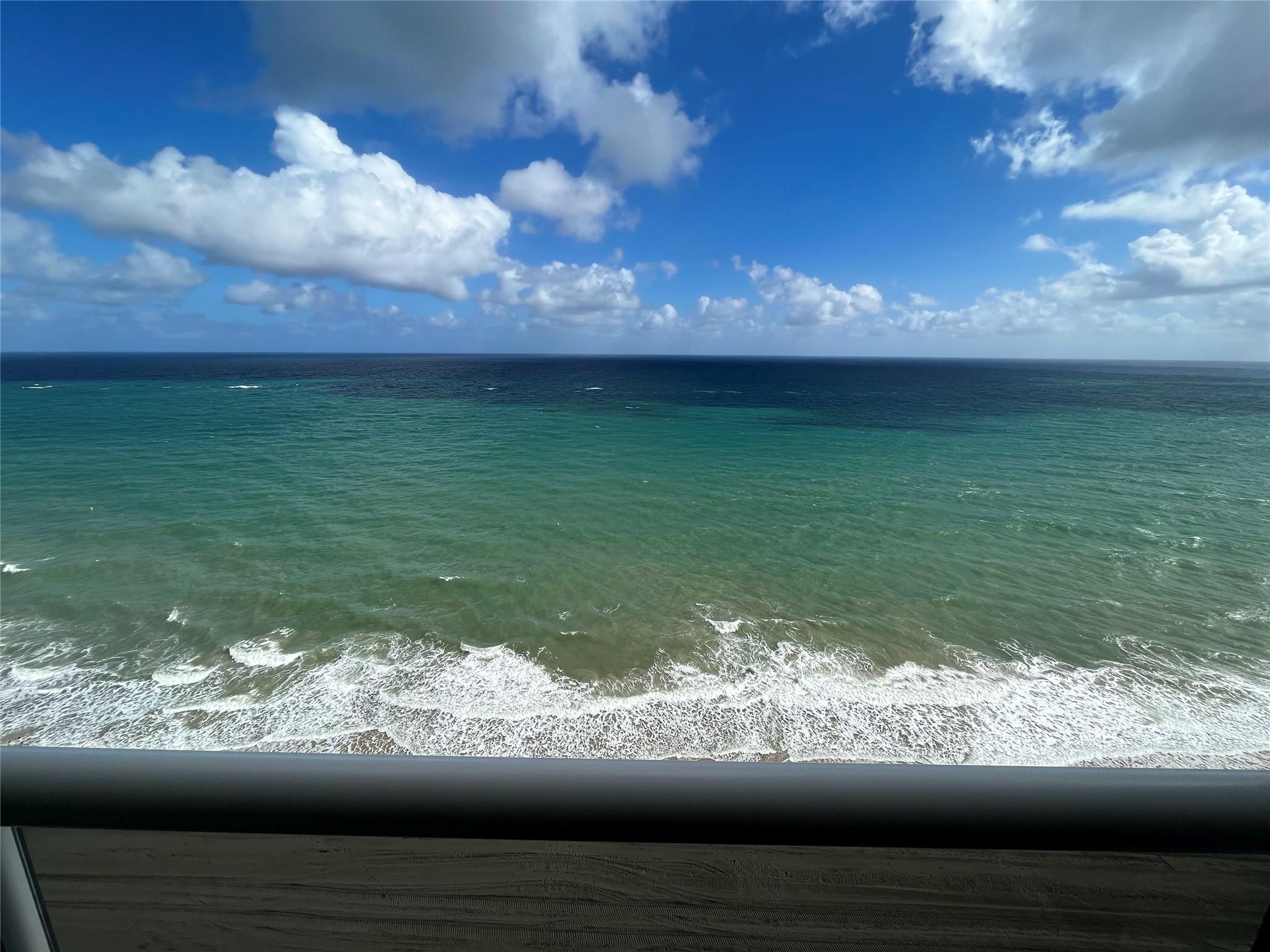 Unobstructed direct view of the ocean showing the glass balcony railing.