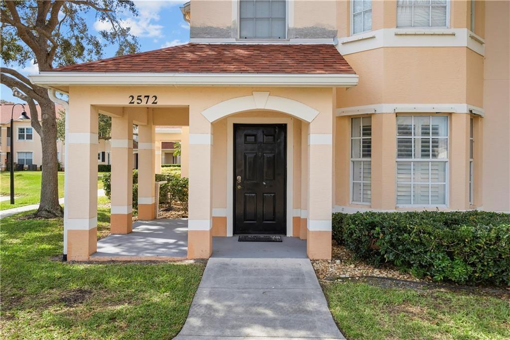 Doorway to property with a shingled roof and stucco siding