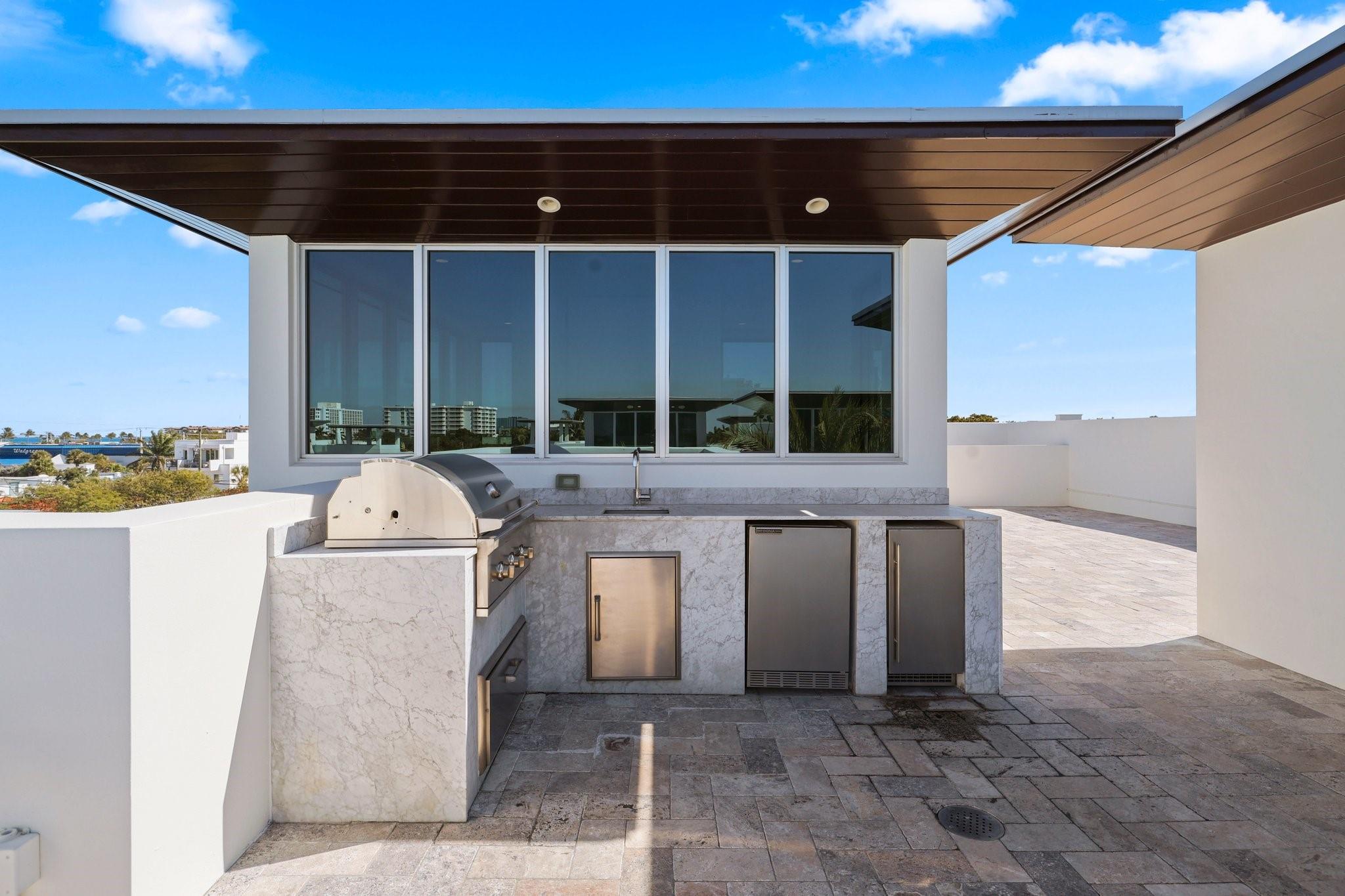 Full summer kitchen with natural gas grill, small fridge and ice maker