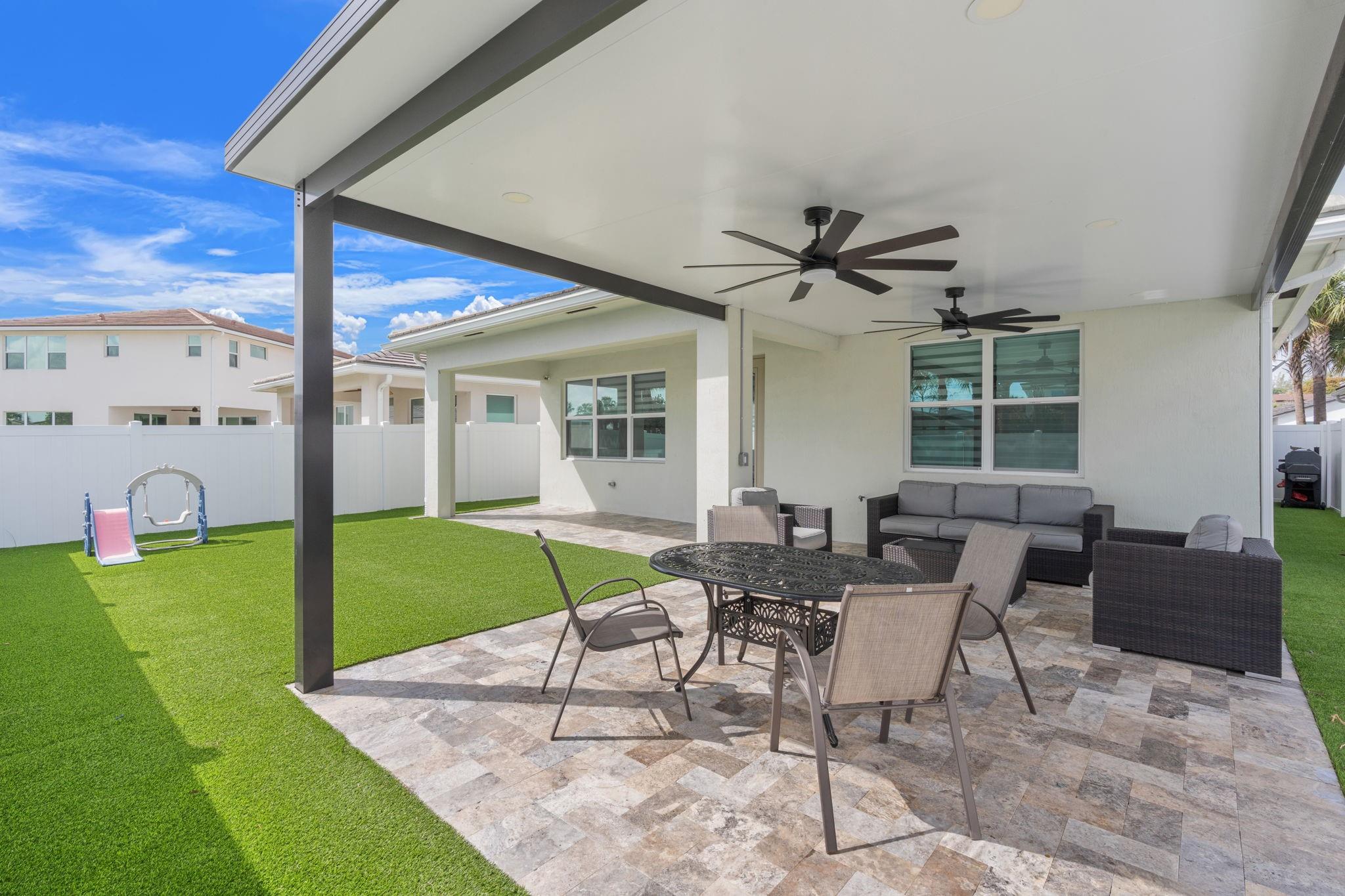 Stay Cool in Your Shaded Backyard with 2 Oversized Fans and Modern Travertine Tile.