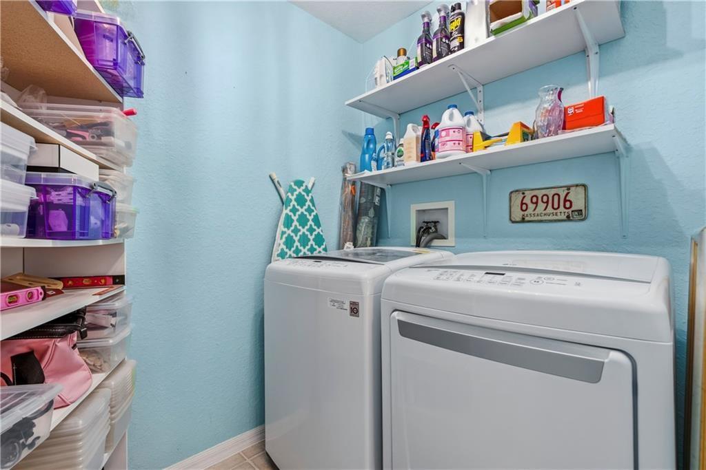 Laundry room with a textured wall and washer and dryer