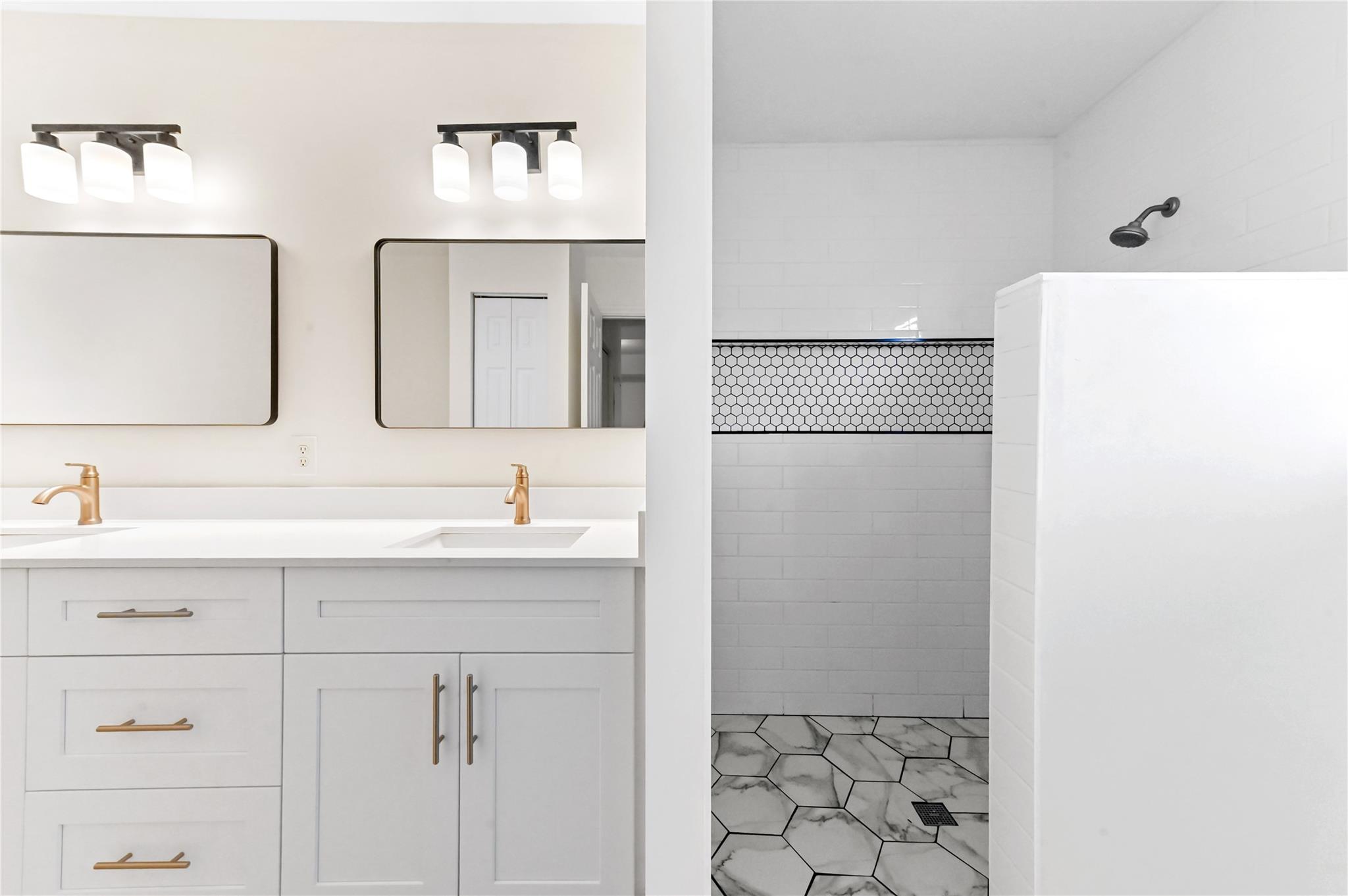 Totally renovated primary bathroom has double sink vanity with quartz counters