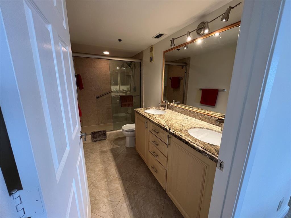 Primary bathroom has double sinks with an updated granite top vanity.