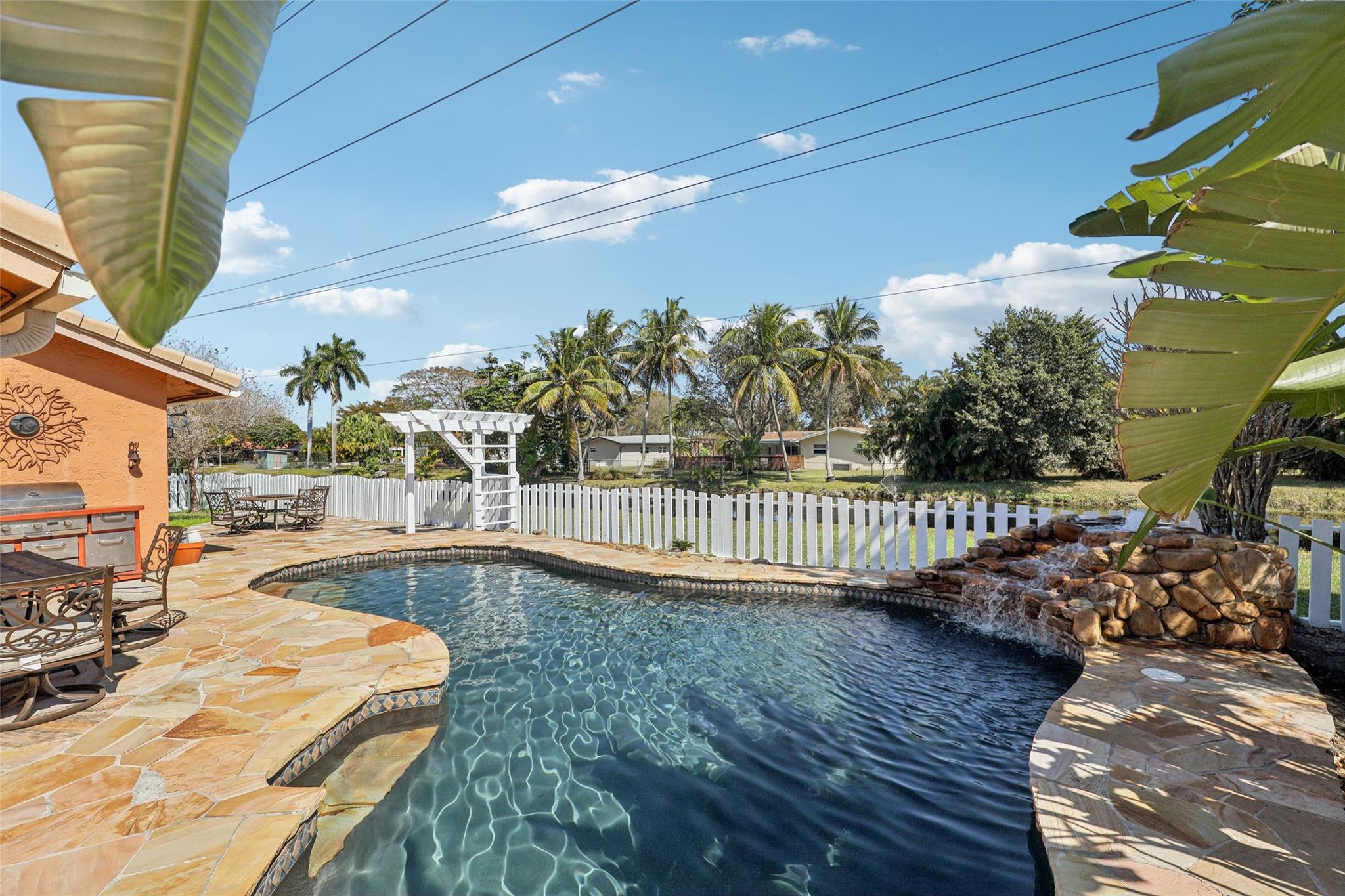 Lagoon-style pool with waterfall feature is ideal for year-round enjoyment!