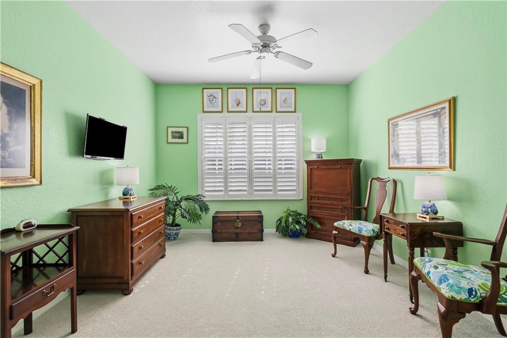 Bedroom 2 with ceiling fan and light colored carpet
