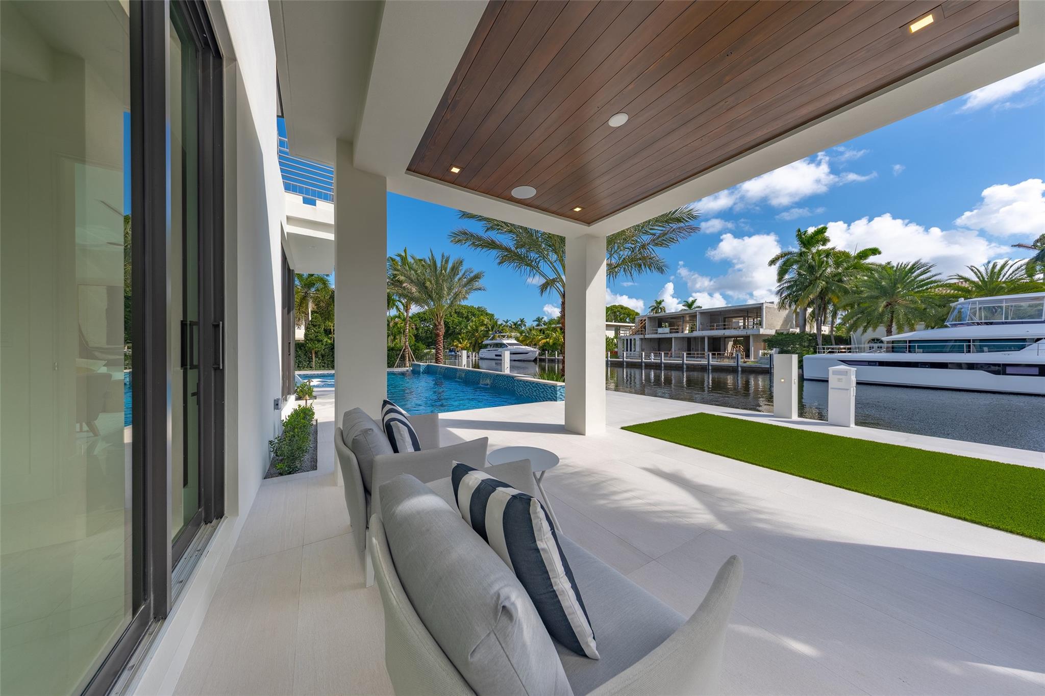 On the first floor, a guest room opens to a covered patio with breathtaking waterfront views,