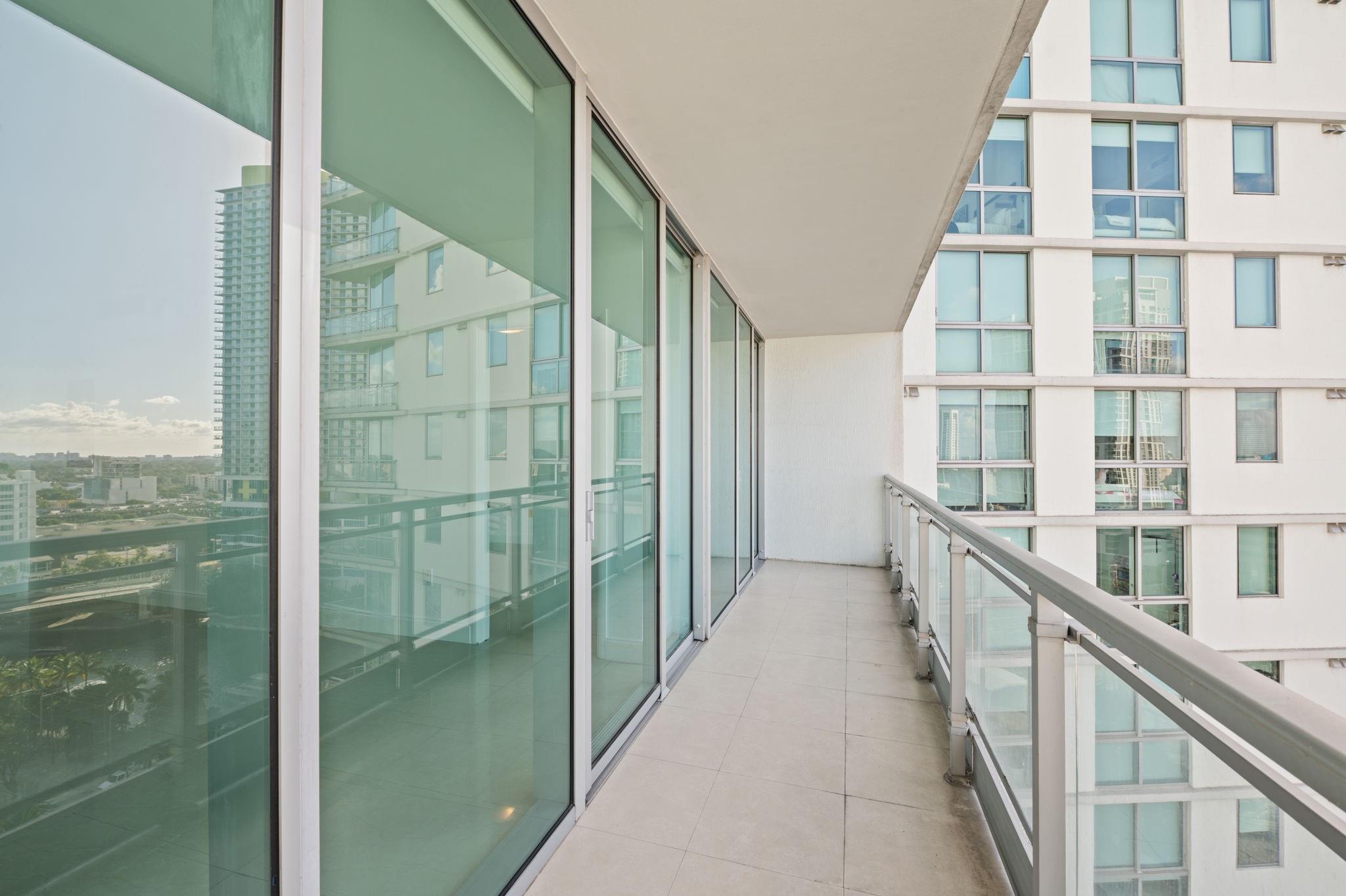 SPACIOUS BEDROOM TO LIVING AREA BALCONY WITH CITY AND RIVER VIEWS. GLASS RAILINGS MAXIMIZE VIEWS: WITH THIS SPACIOUS BALCONY, THE TOTAL AREA OF THIS APARTMENT 1807 IS 923 SQUARE FEET.