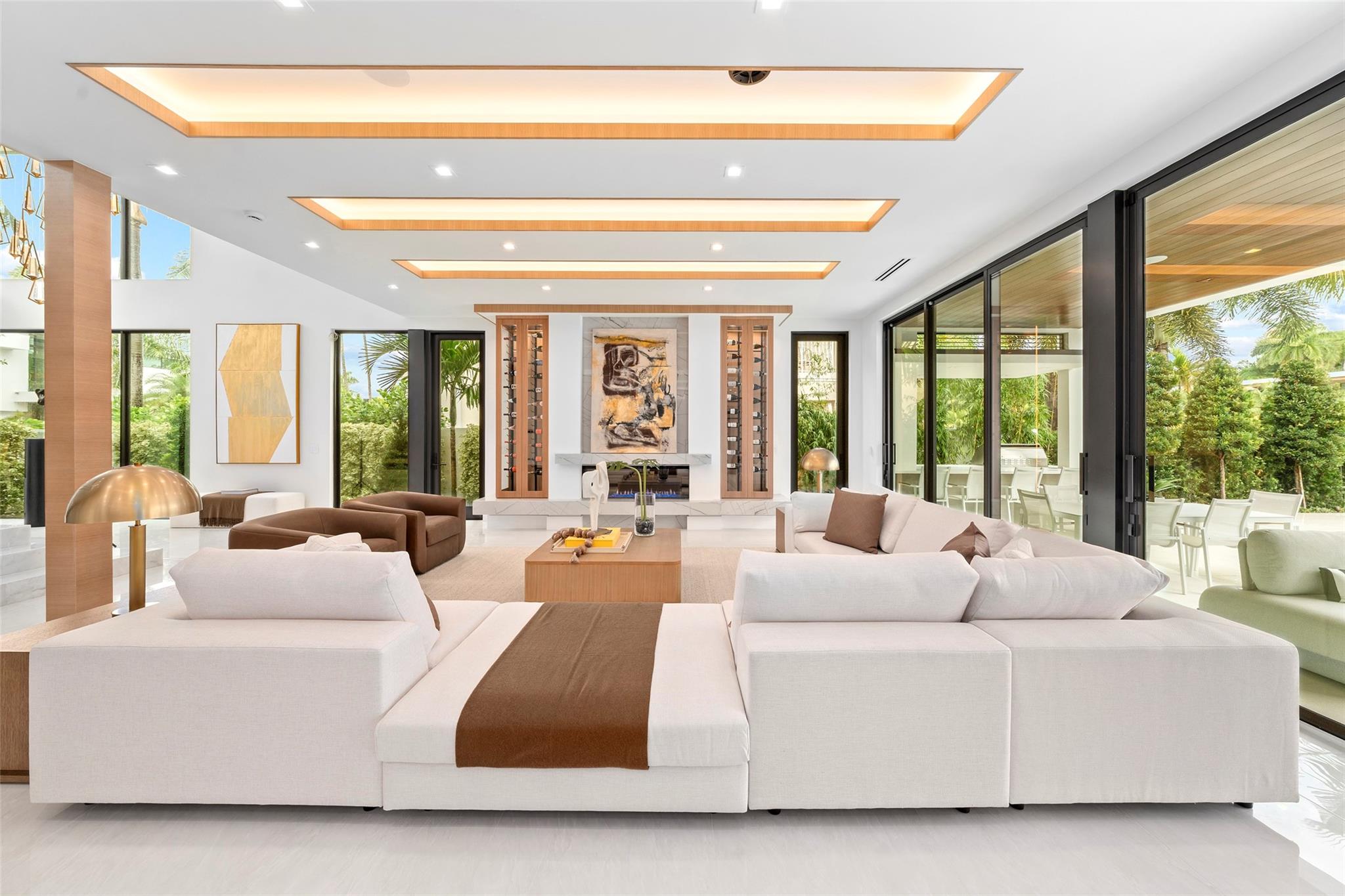 The home features a beautifully designed formal living area with soaring ceilings, expansive windows, and stunning waterway views that capture the essence of luxury waterfront living. The open layout is perfect for entertaining, seamlessly connecting the living room to the dining and outdoor spaces.