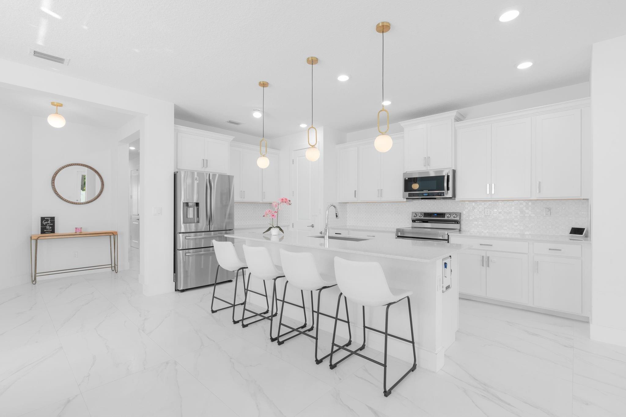 Updated Flooring throughout the First Floor, Bright Kitchen with Oversized Cabinets, Quartz Counter Tops, Marble Backsplash, Upgraded Appliances and Light Fixtures