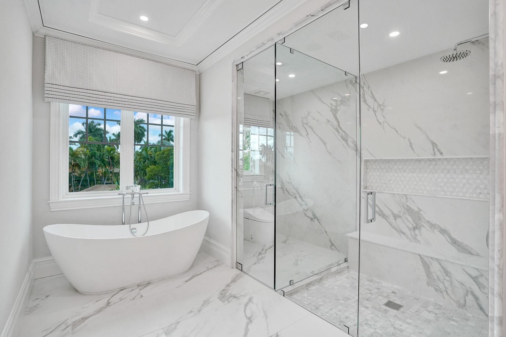 The primary suite boasts separate his-and-hers bathrooms; her bathroom features a spa-like soaking tub, makeup vanity, and a spacious walk-in closet.