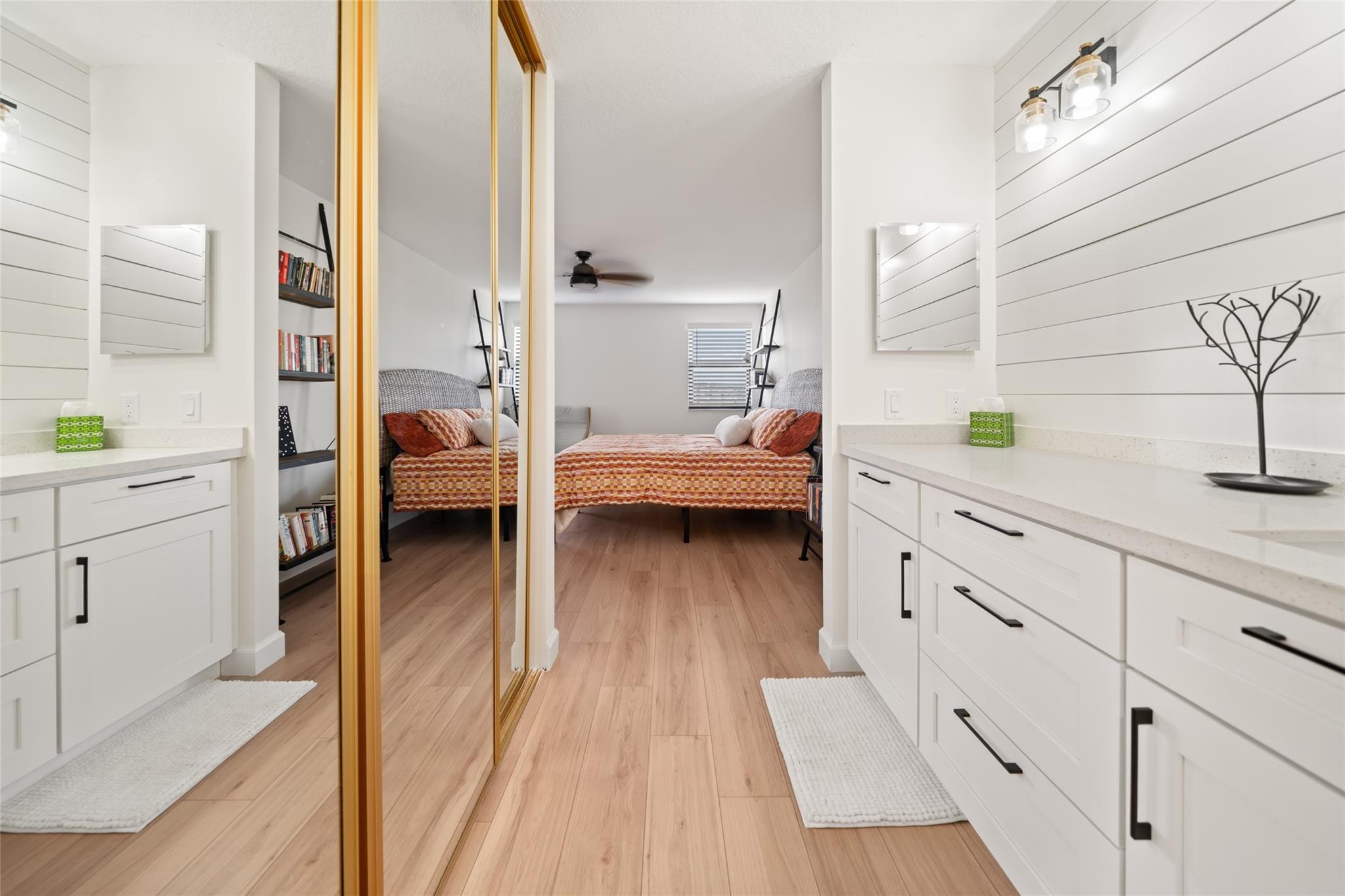 Primary dressing area leading into walk-in closet and bathroom