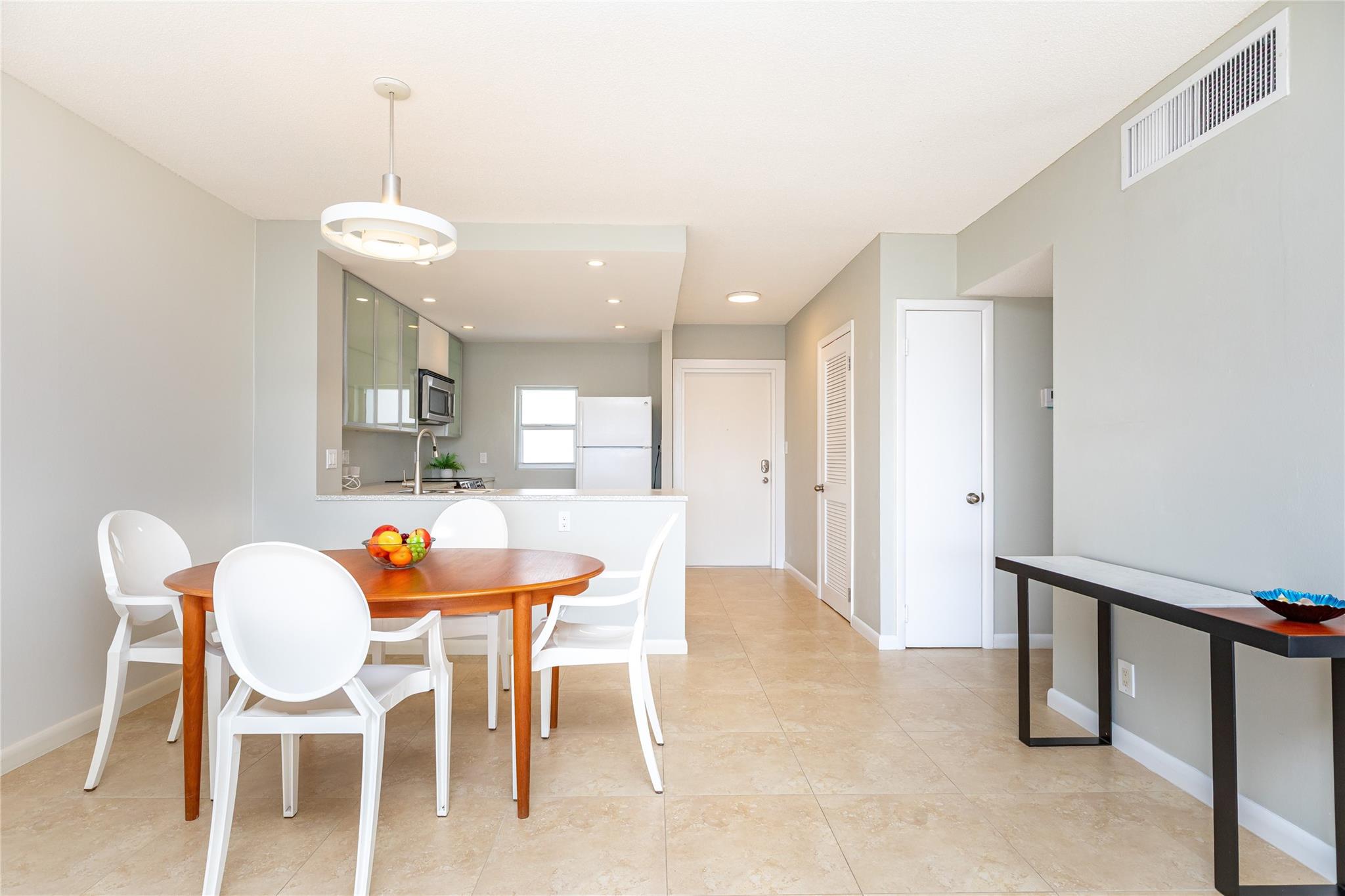 View from living into dining into kitchen with entry door in background.