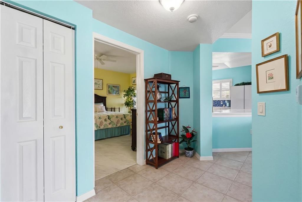 Corridor featuring a textured ceiling and light tile patterned floors