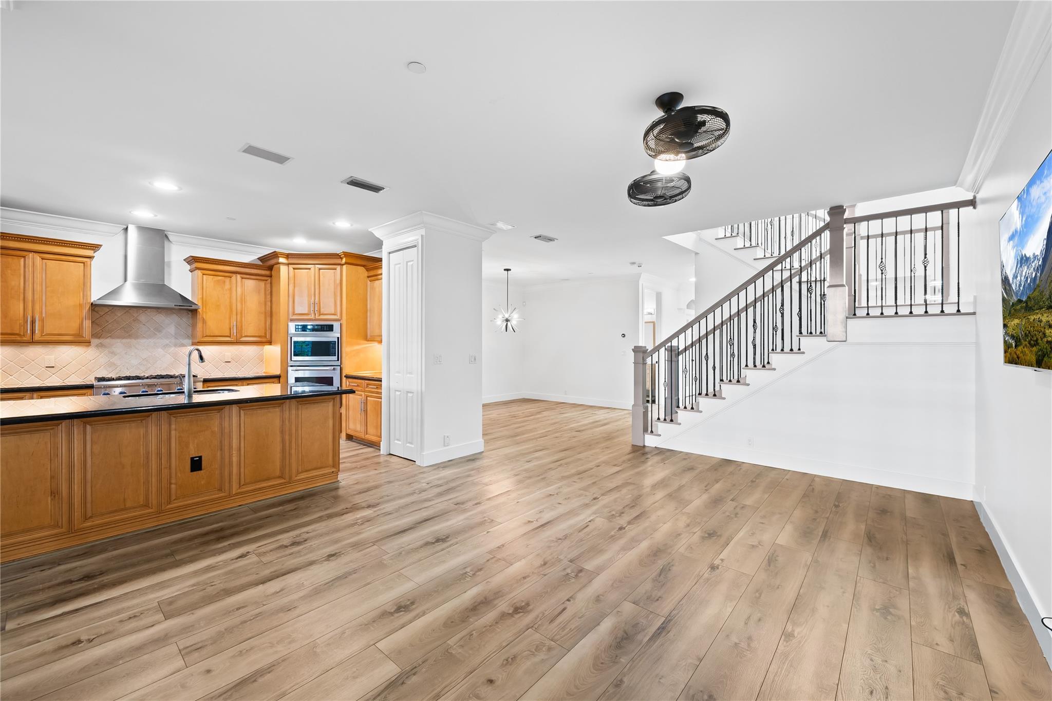 Entertainment area with view of kitchen and stairs