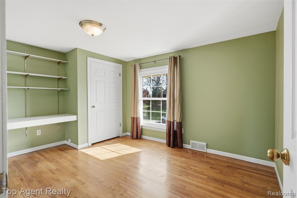Unfurnished office with light wood-type flooring and baseboards