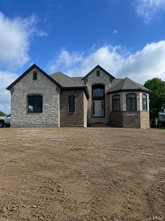 Stone and brick veneer exterior with an arched entry window and a multi-level roofline