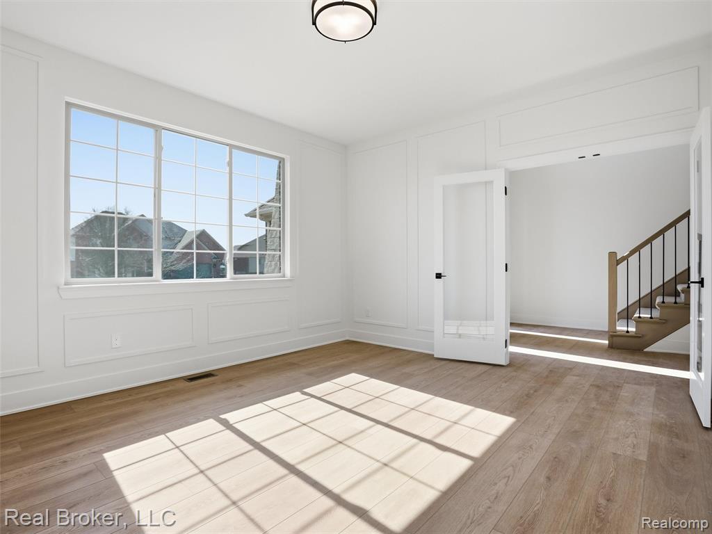 Empty room featuring light wood-type flooring and a decorative wall