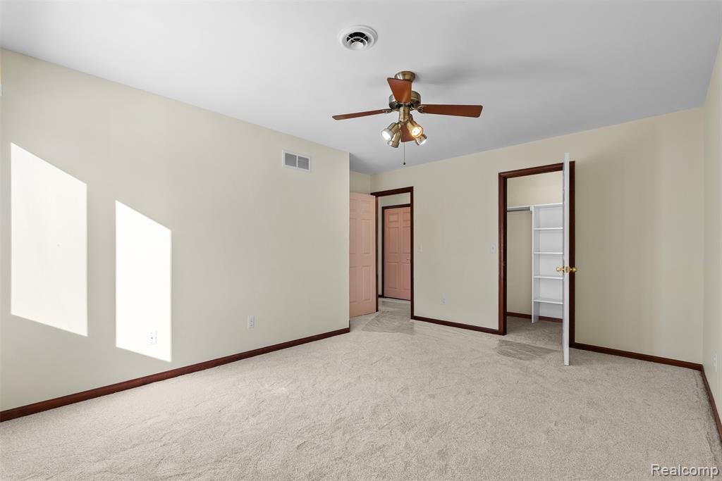 Unfurnished bedroom with light carpet, a ceiling fan, and a closet