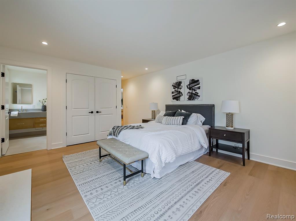 Bedroom with recessed lighting, light wood finished floors, a closet, and connected bathroom