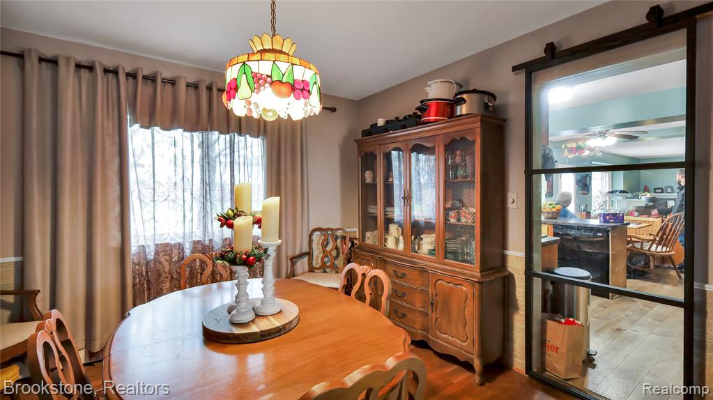 Dining space with wood finished floors and hanging lights