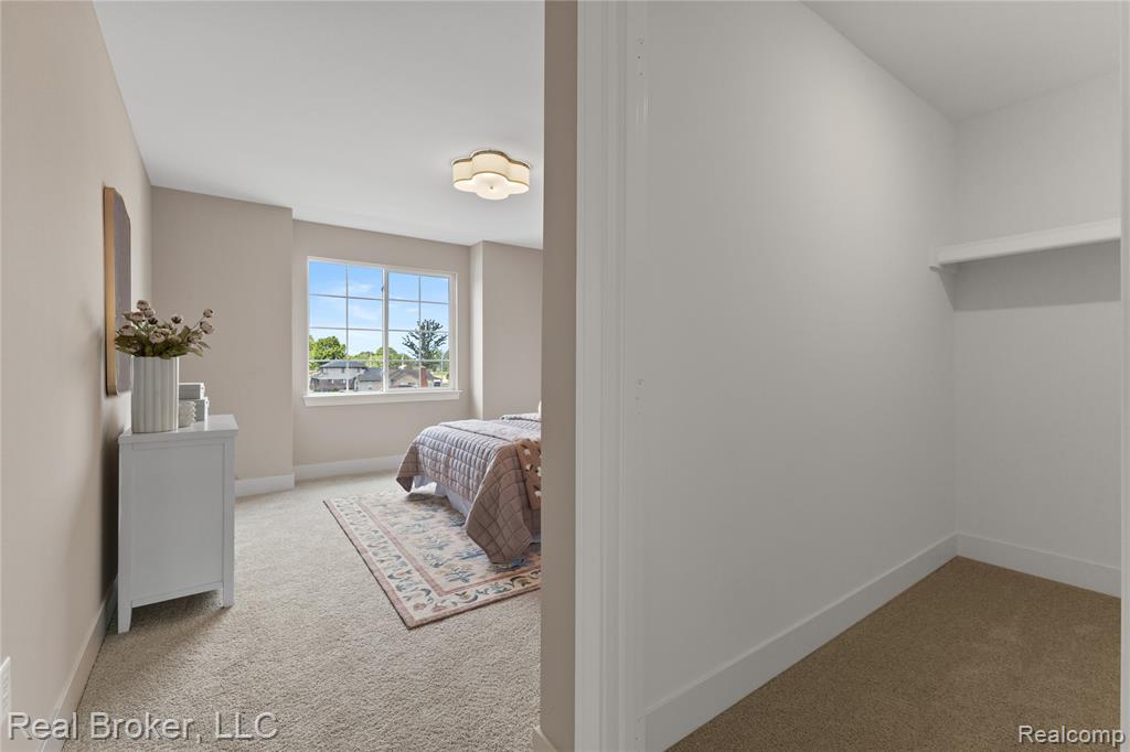 Bedroom featuring light carpet and baseboards