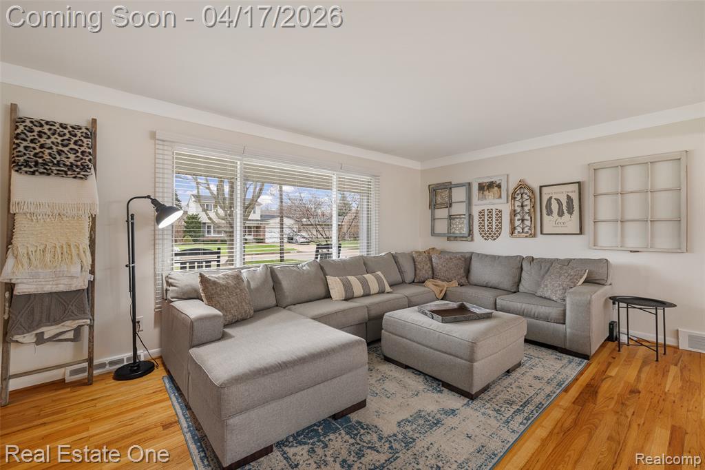 Living room featuring light wood finished floors and ornamental molding